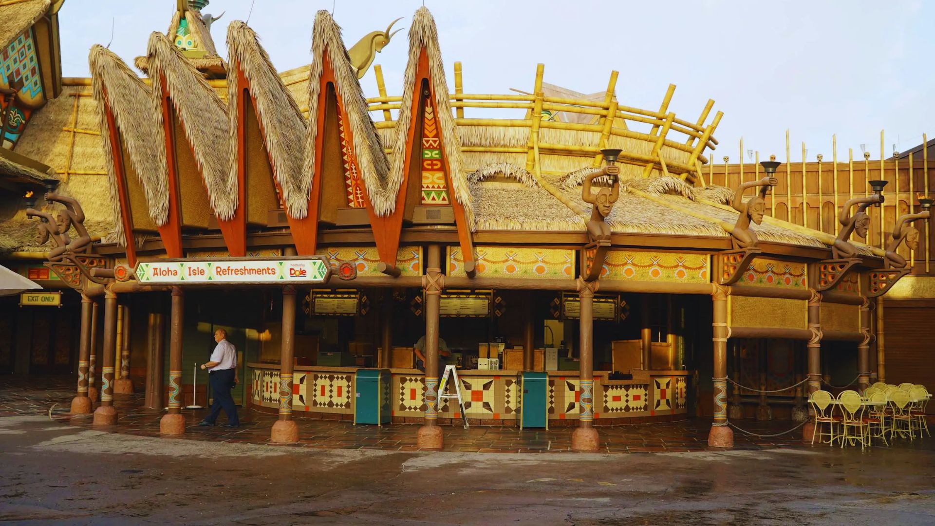 A wooden bar with a large roof, showcasing a rustic design and inviting atmosphere.