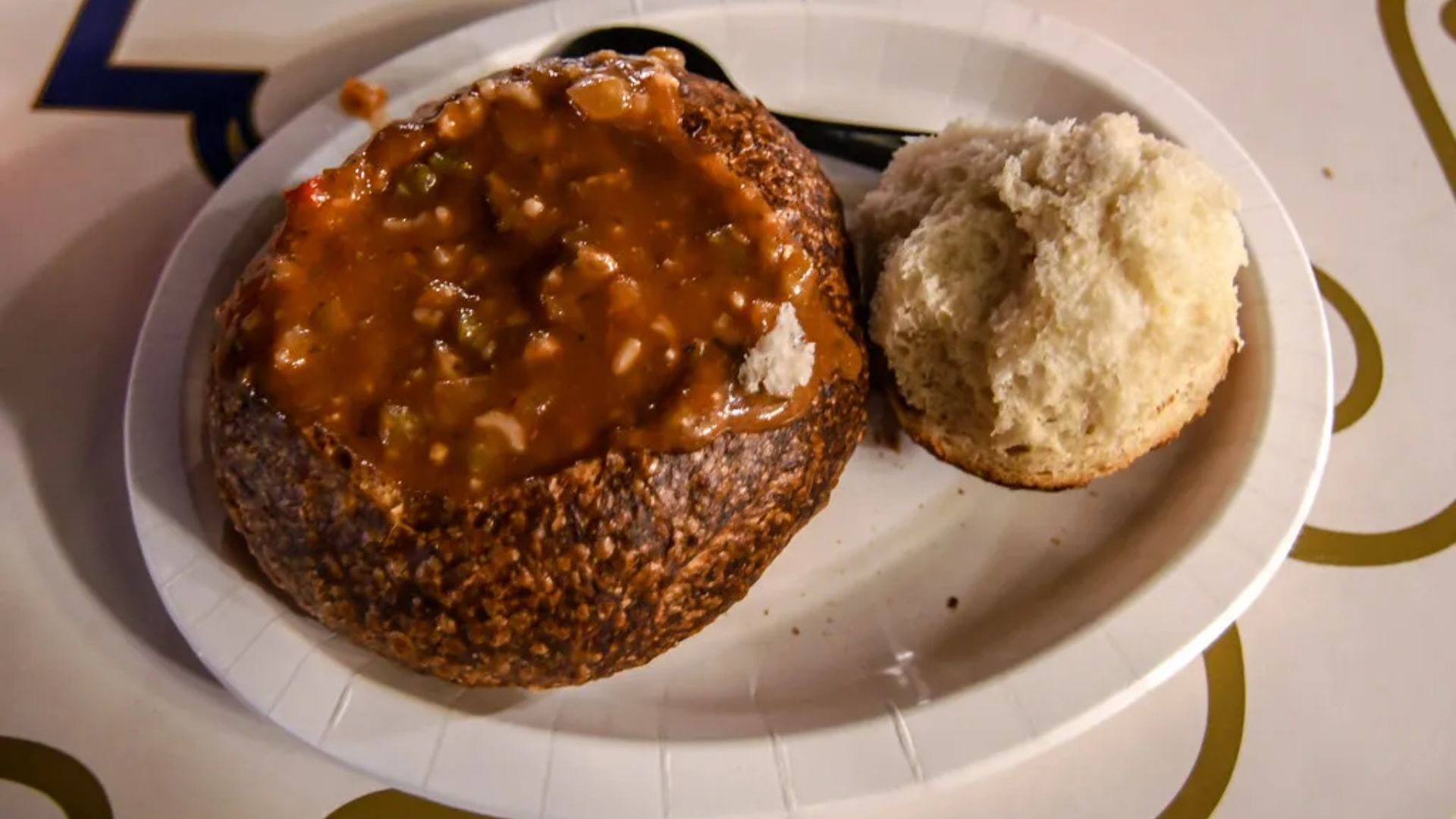 A plate featuring a sandwich alongside a biscuit, showcasing a simple meal arrangement.