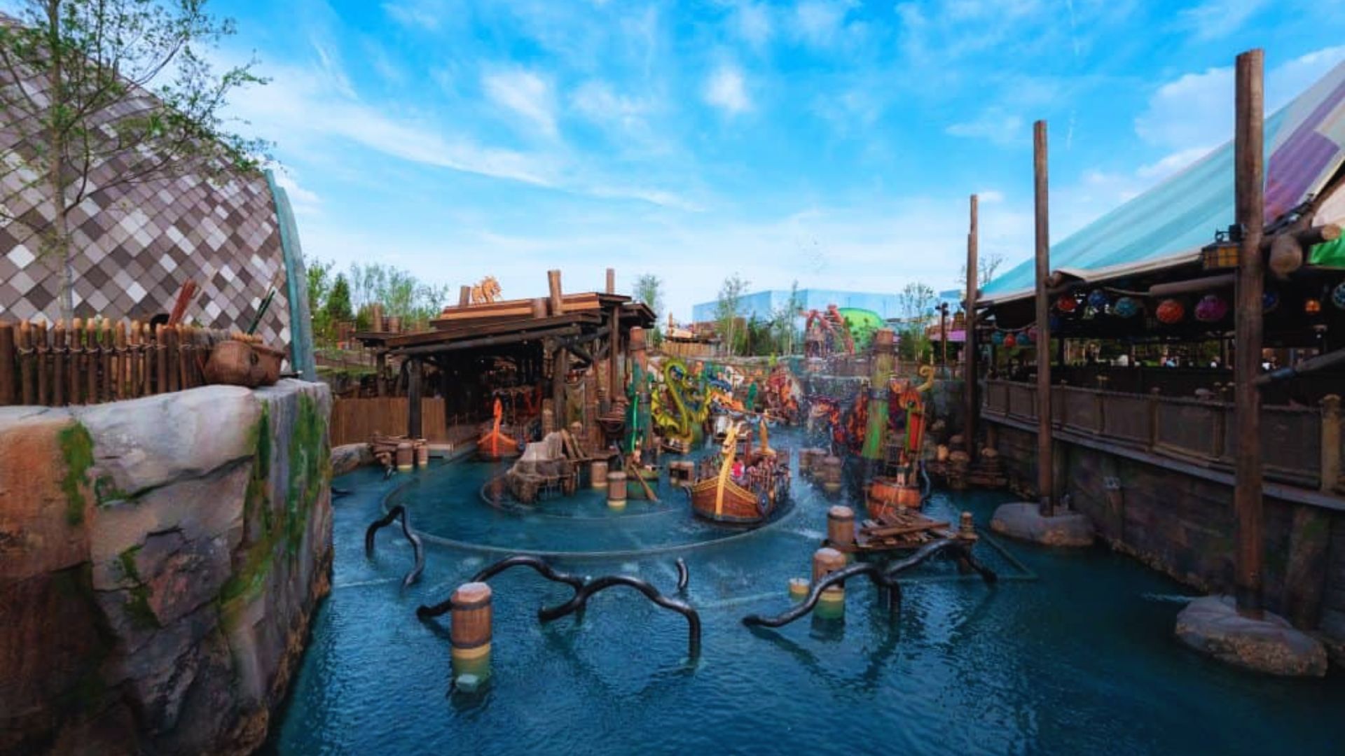 A vibrant water park at Disney's Hong Kong Resort featuring slides, pools, and lush landscaping under a clear blue sky.