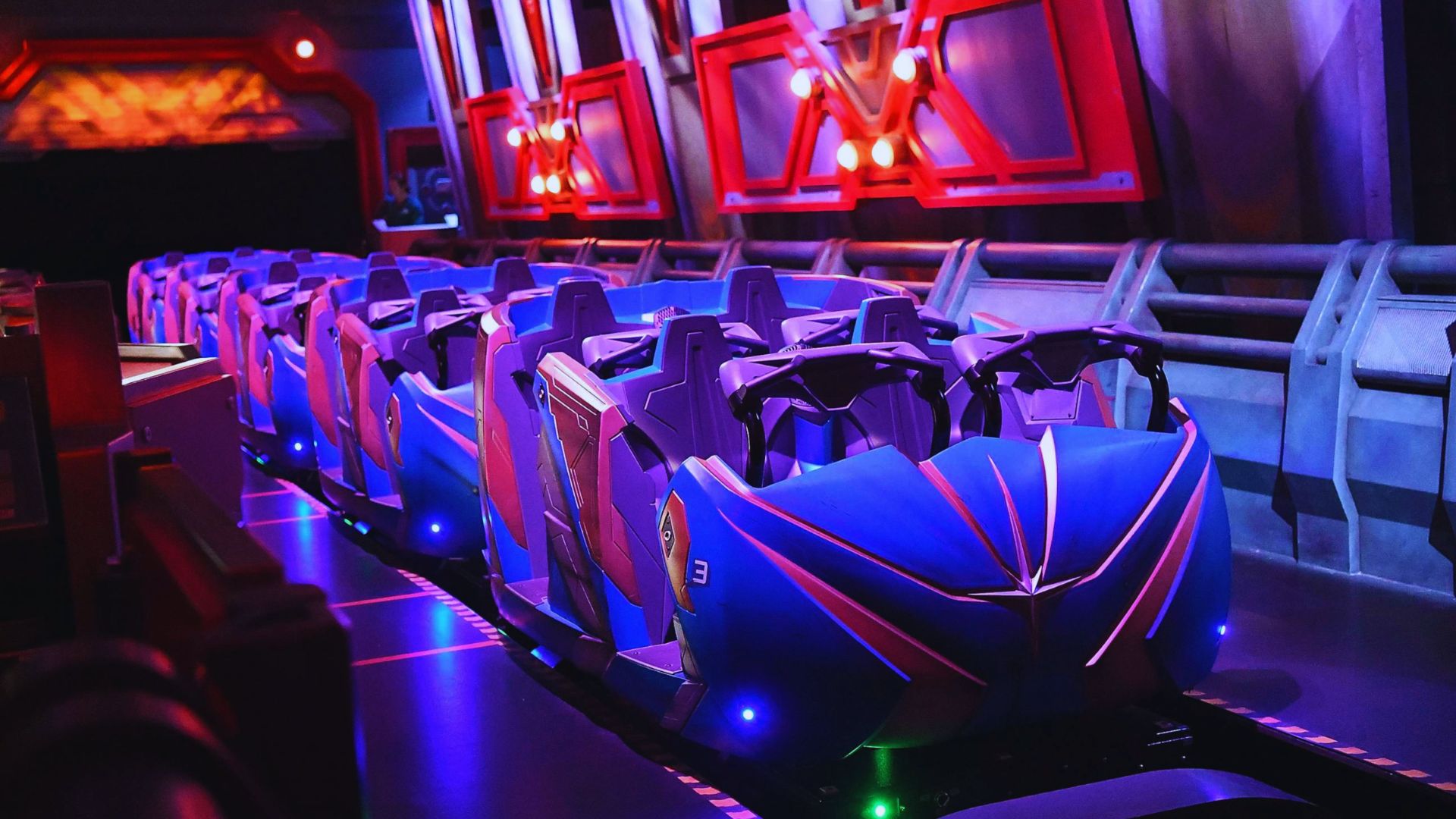 A thrilling roller coaster ride illuminated by vibrant purple lights against a night sky.