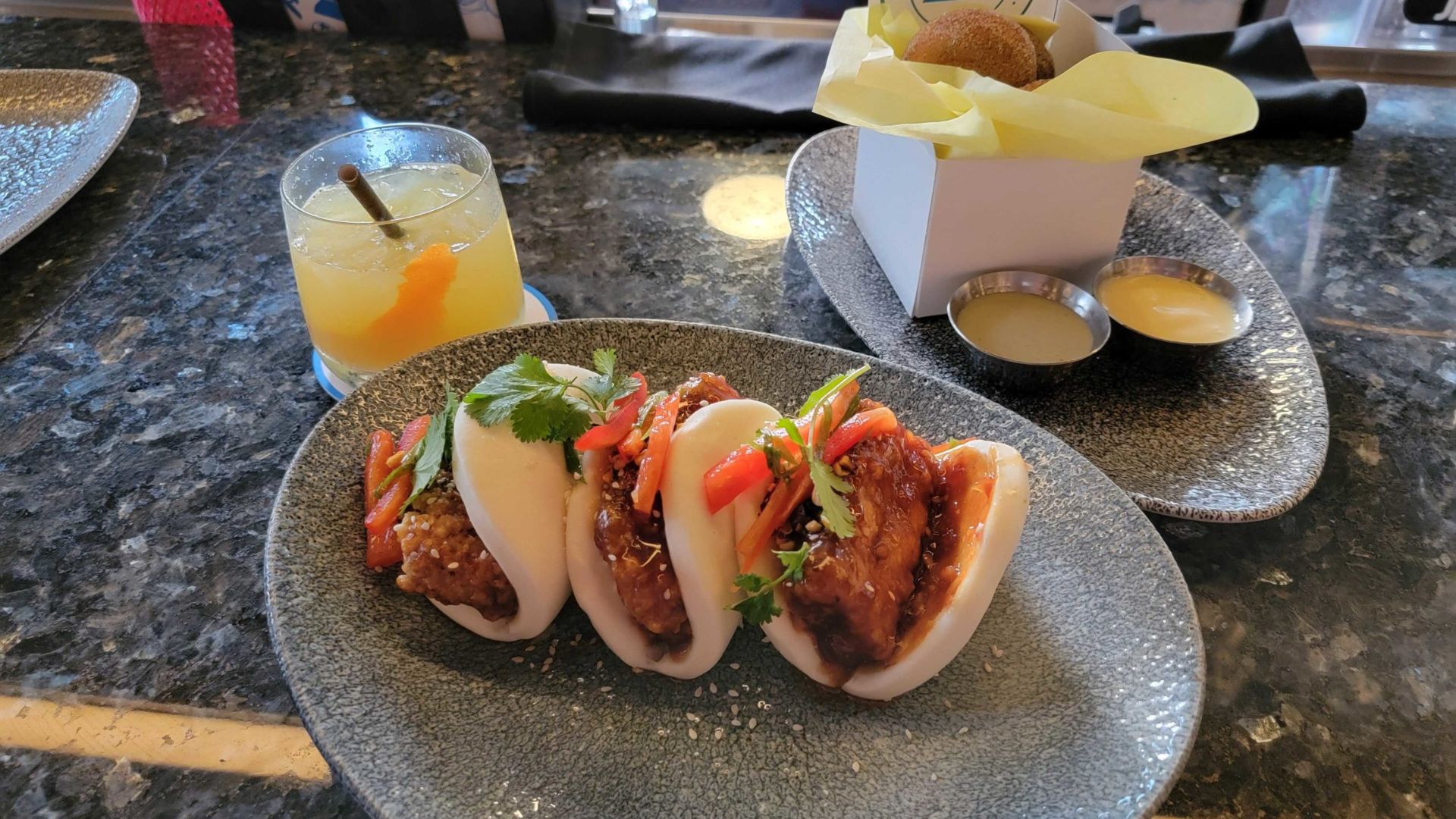 Two plates of food and a drink are arranged on a table, showcasing a meal setting.