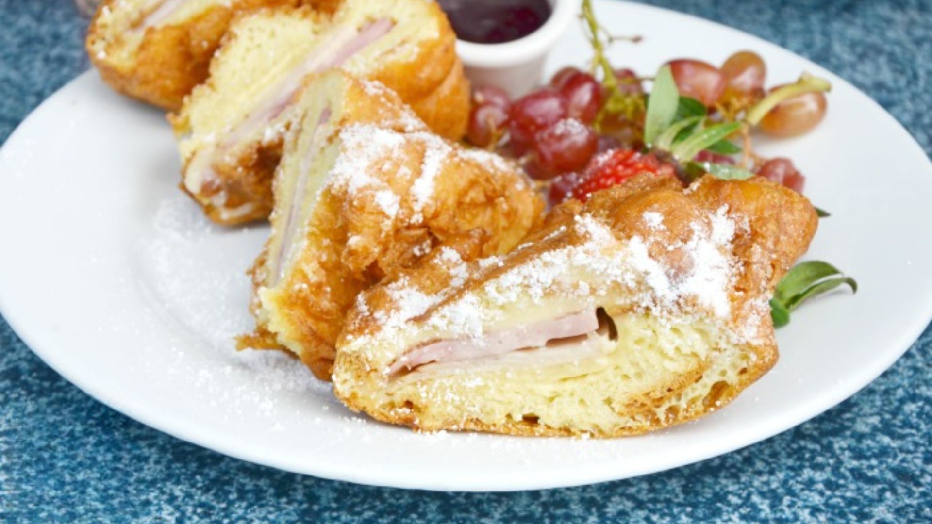 A plate featuring a golden croissant alongside a variety of fresh fruit.