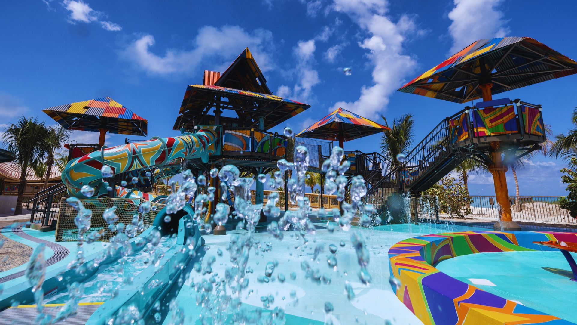 A vibrant water park featuring a large slide and a twisting water slide surrounded by colorful attractions.