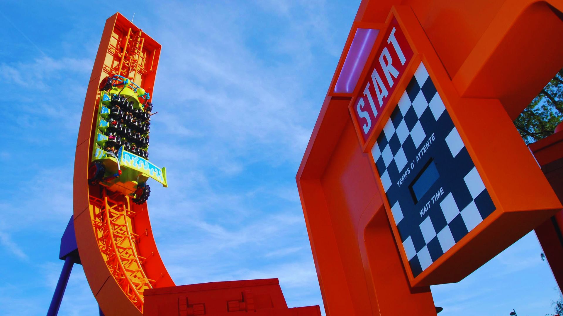 A thrilling roller coaster ride with steep drops and twists, filled with excited riders raising their hands in the air.