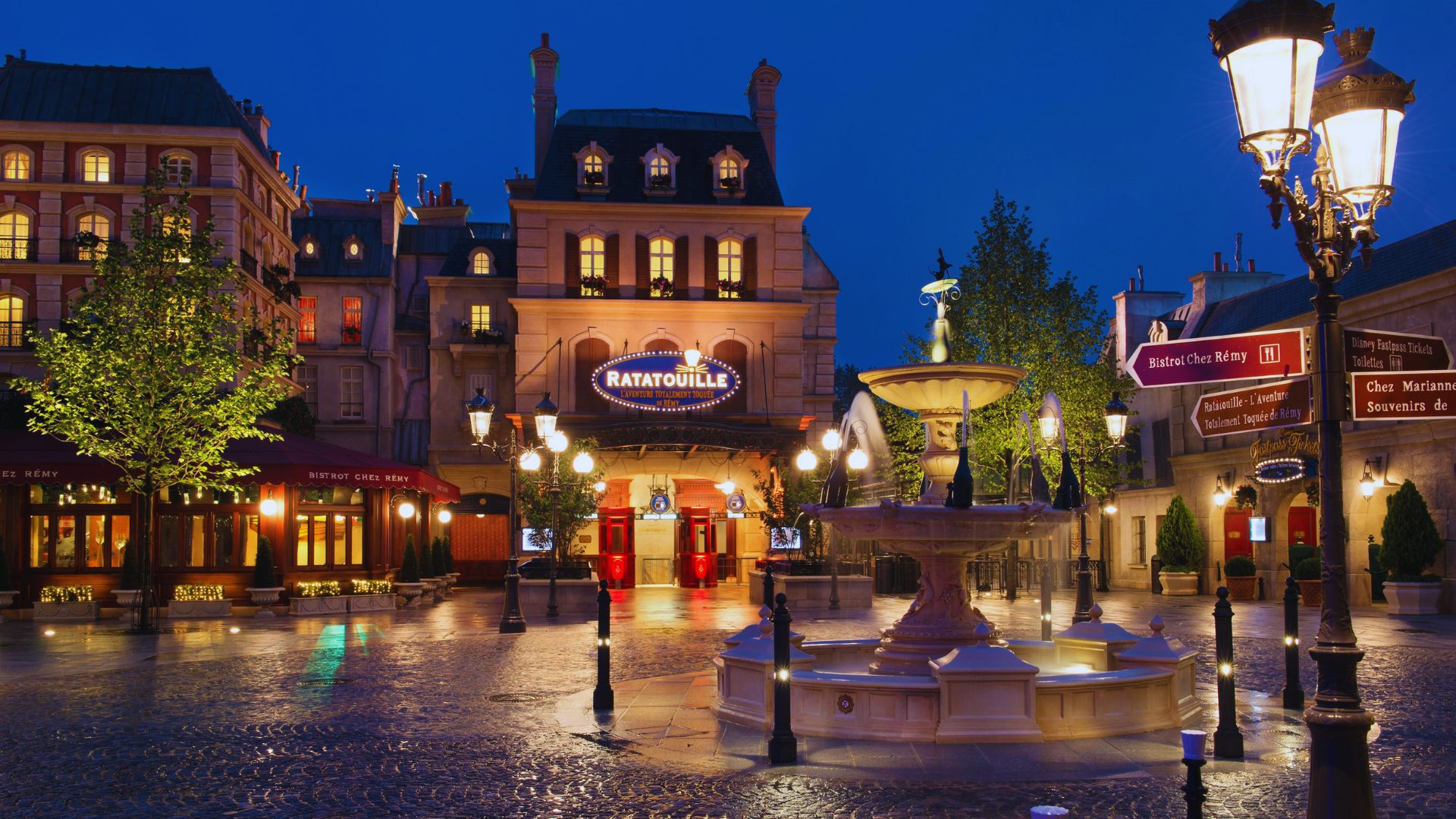 A decorative fountain located in the center of a bustling city street, surrounded by buildings and pedestrians.