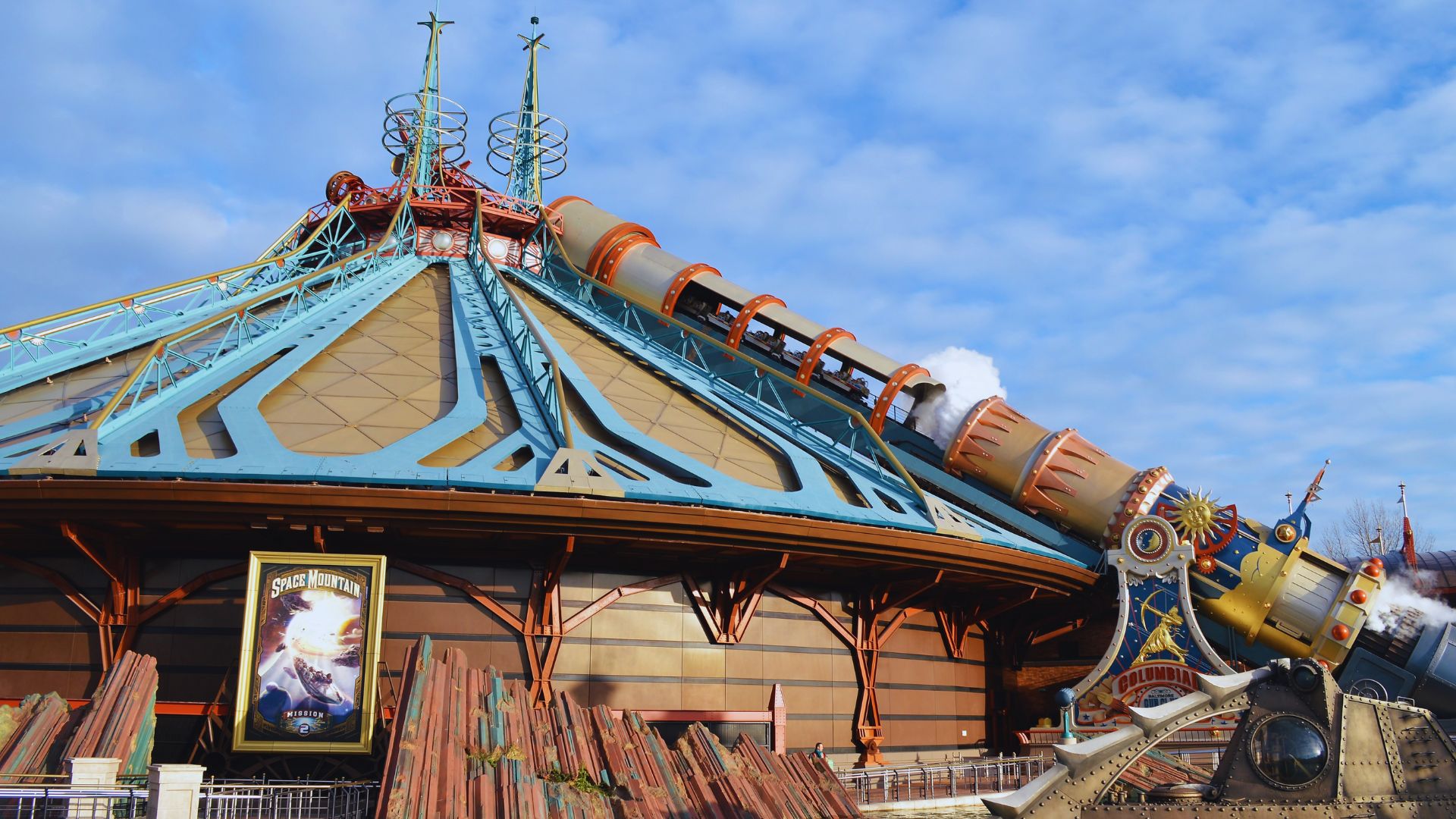 A futuristic spaceship structure at Disneyland Paris, surrounded by vibrant landscaping and visitors enjoying the attraction.