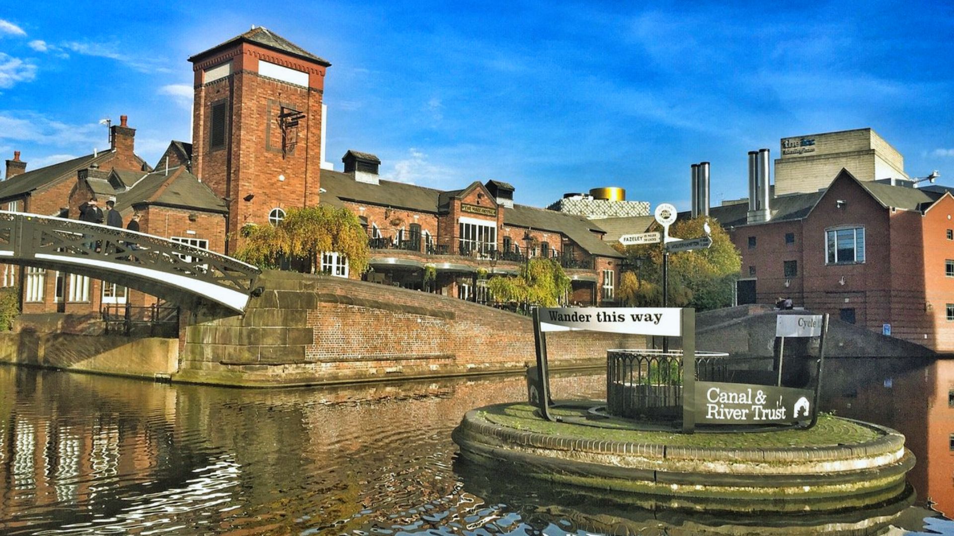 A scenic canal with a bridge and buildings visible in the background, showcasing urban architecture and waterway.