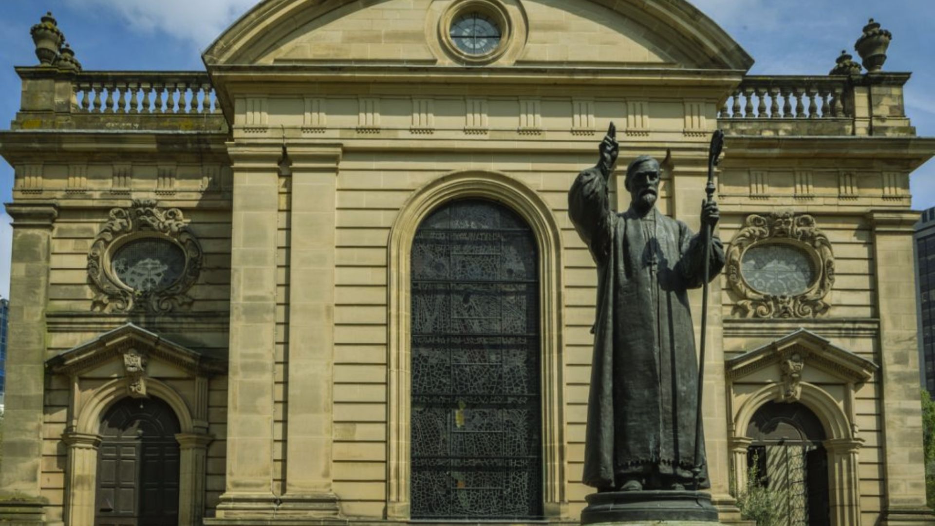 A large building featuring a prominent statue of a man in front, showcasing architectural details and the statue's expression.