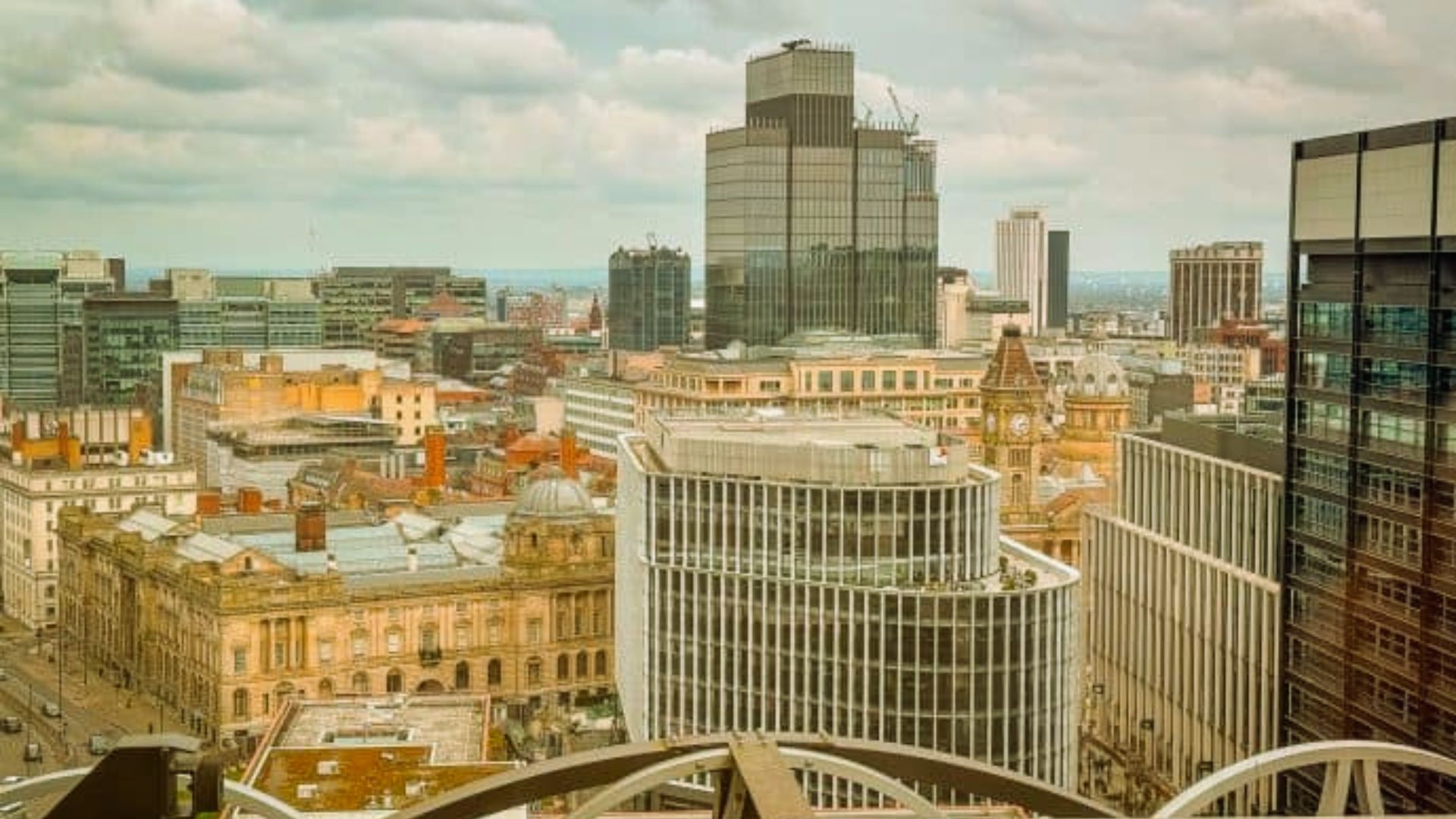 A panoramic view of the city skyline from the rooftop of a tall building, showcasing urban architecture and landscape.