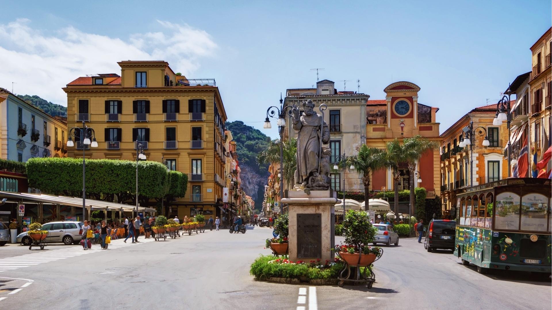 A bustling Italian street lined with historic buildings and people strolling along the cobblestone path.