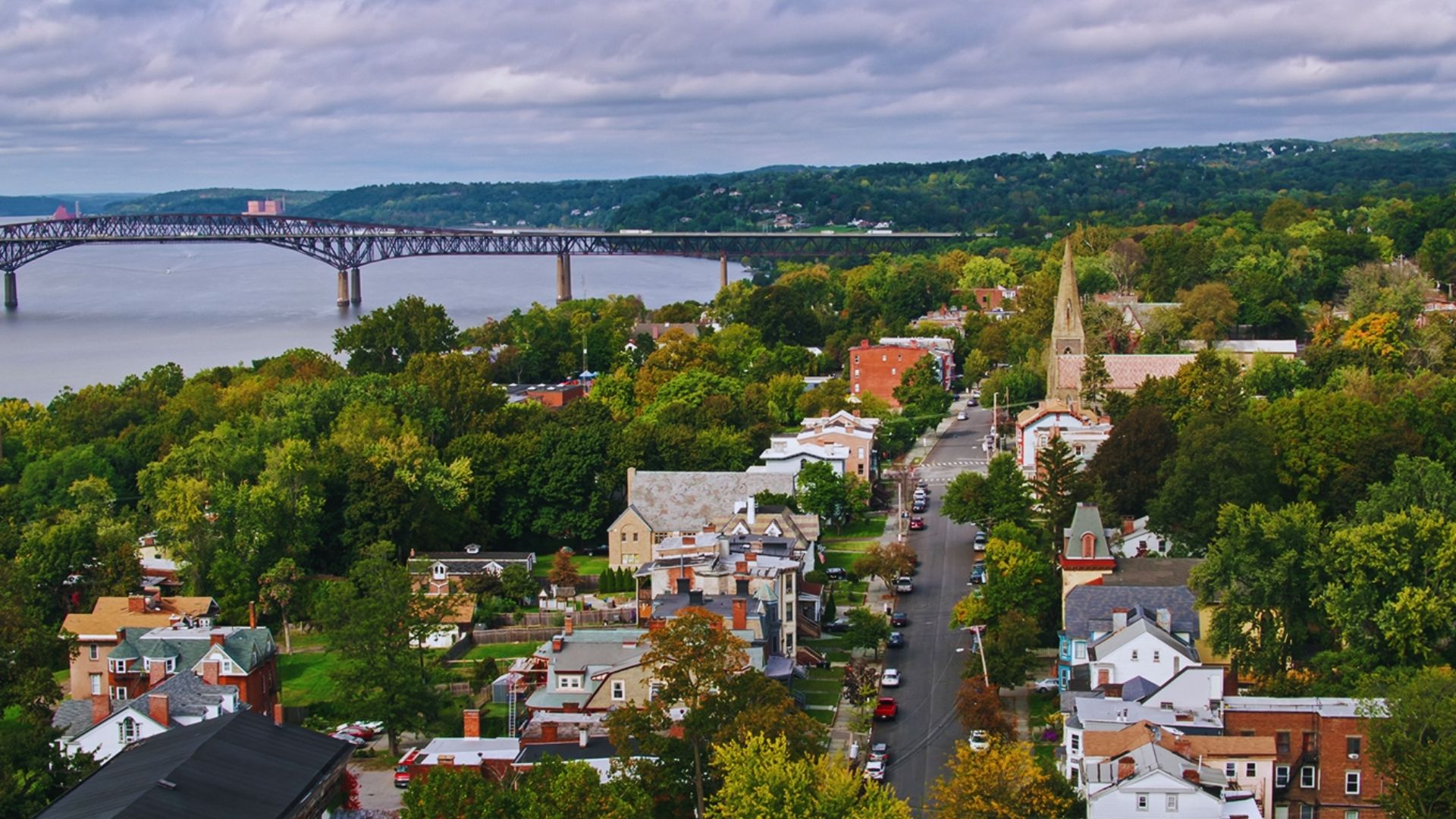 A scenic view of a bridge spanning a river, with a picturesque town visible in the background.