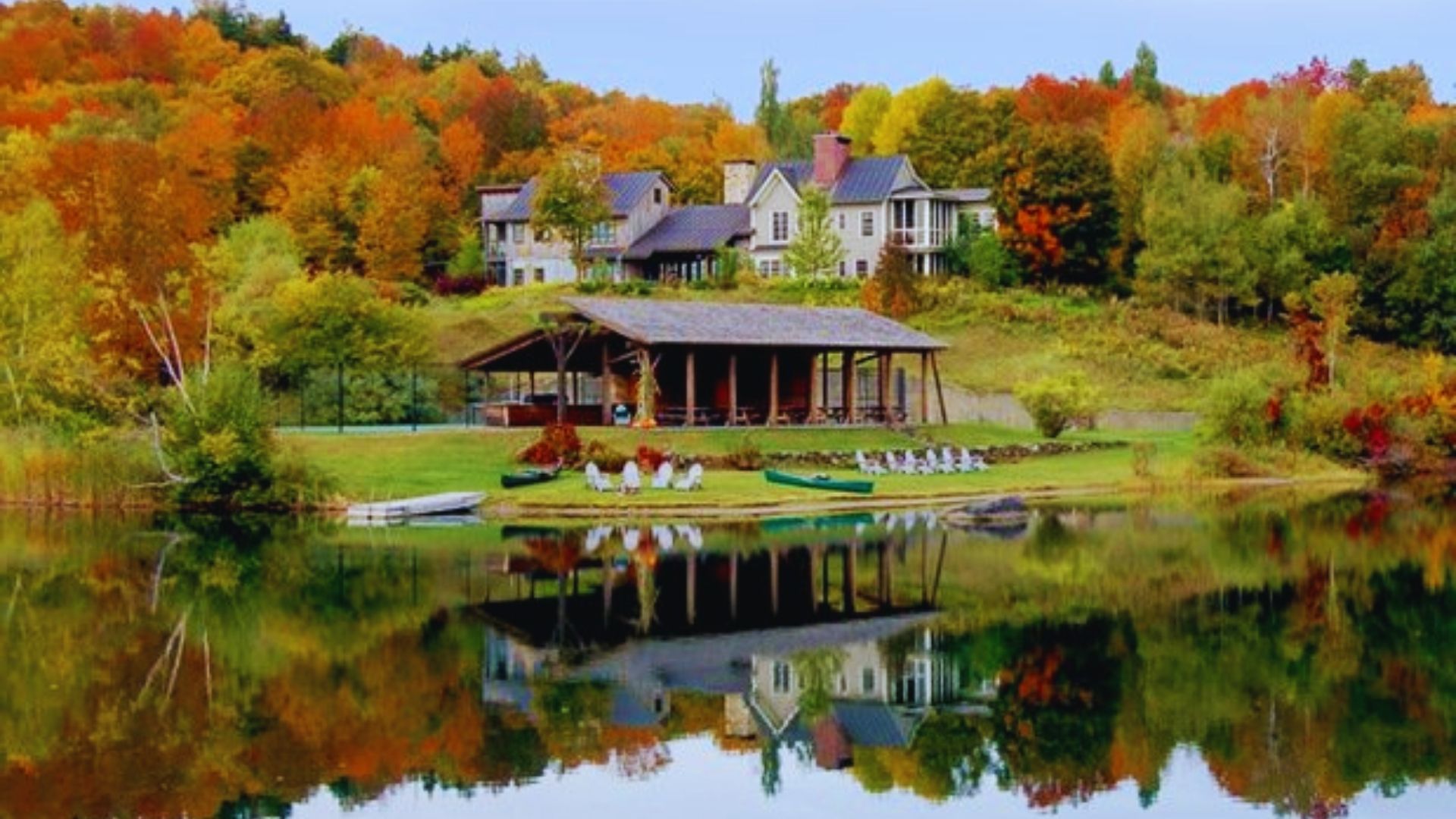 A cozy lake house nestled among vibrant fall foliage, showcasing a picturesque autumn landscape.