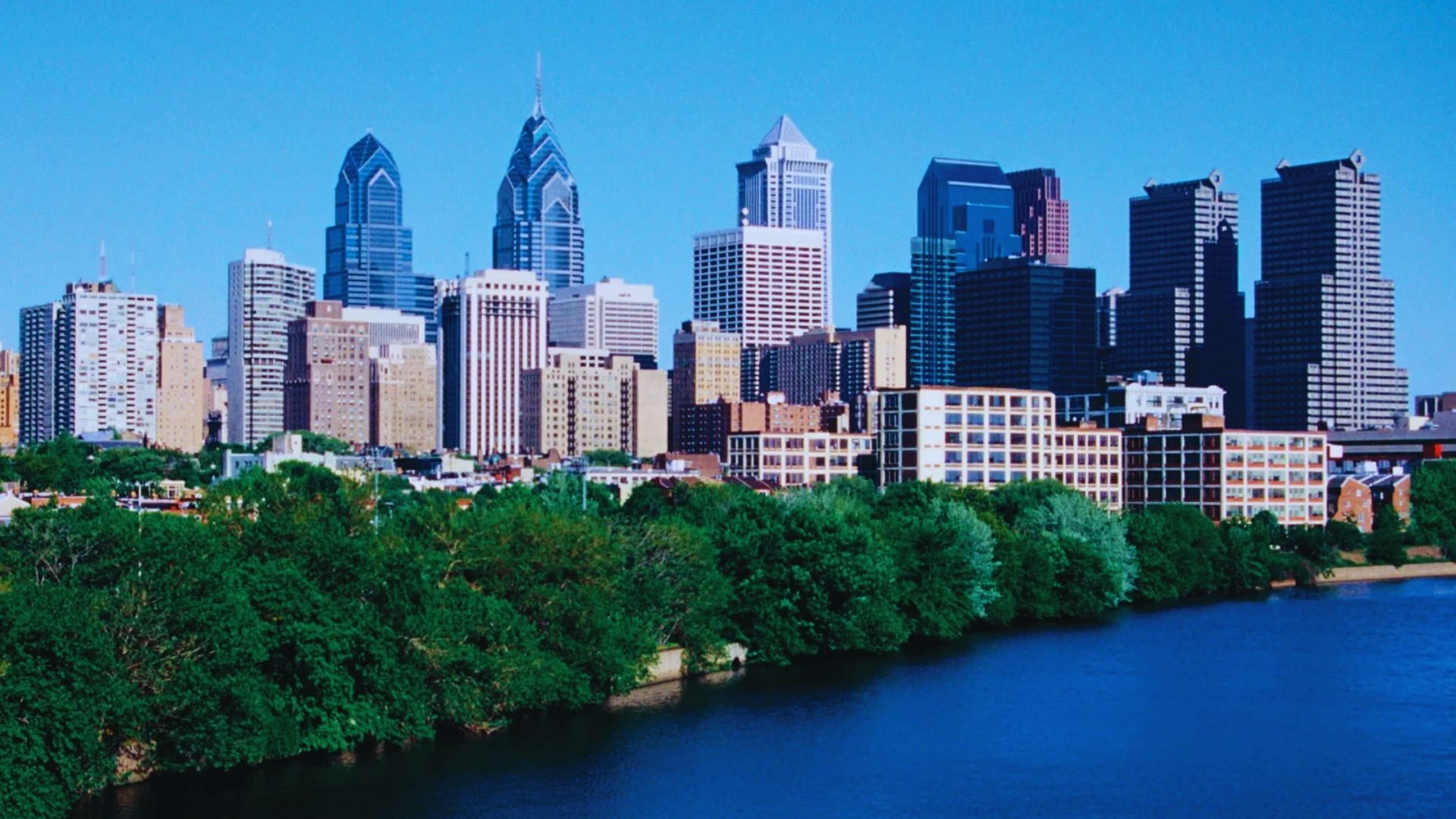 Philadelphia skyline featuring iconic skyscrapers against a clear blue sky, showcasing the city's urban landscape.