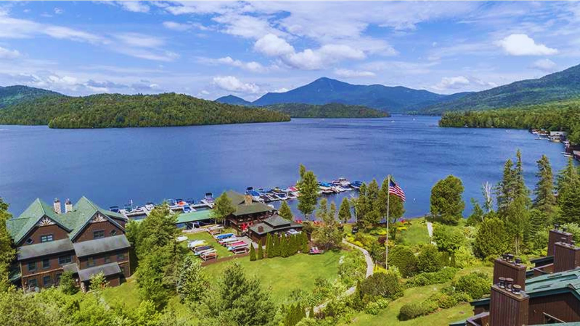 Tranquil lake view at the lodge, surrounded by lush greenery and reflecting the clear blue sky.
