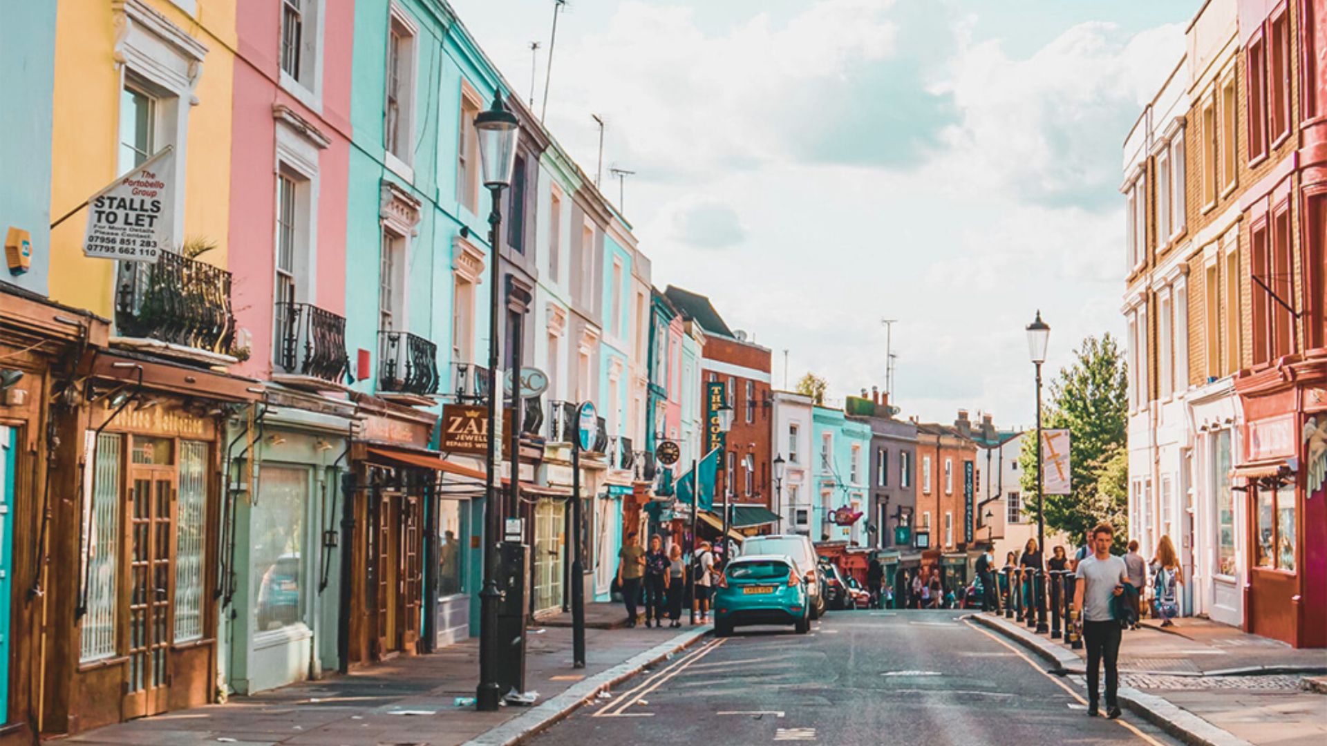 A vibrant street lined with colorful buildings, bustling with people walking and enjoying the lively atmosphere.