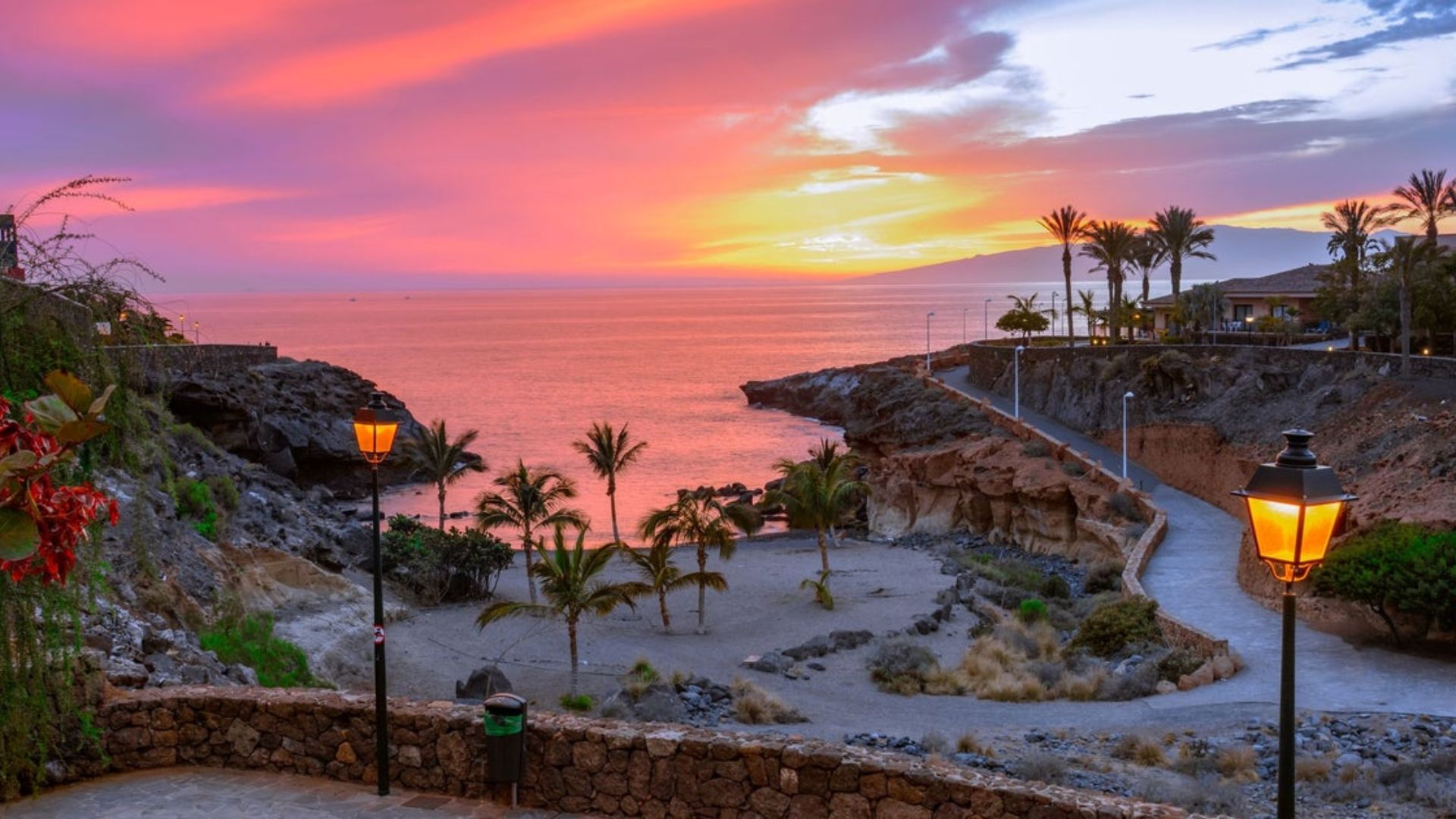 Sunset over the ocean in the Canary Islands, with vibrant orange and purple hues reflecting on the water's surface.