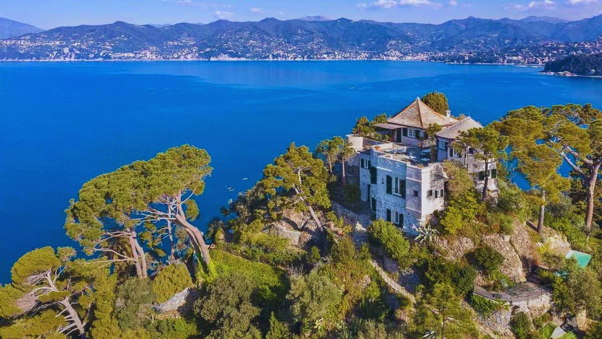 A majestic castle on a hill, providing a panoramic view of the ocean in the distance.