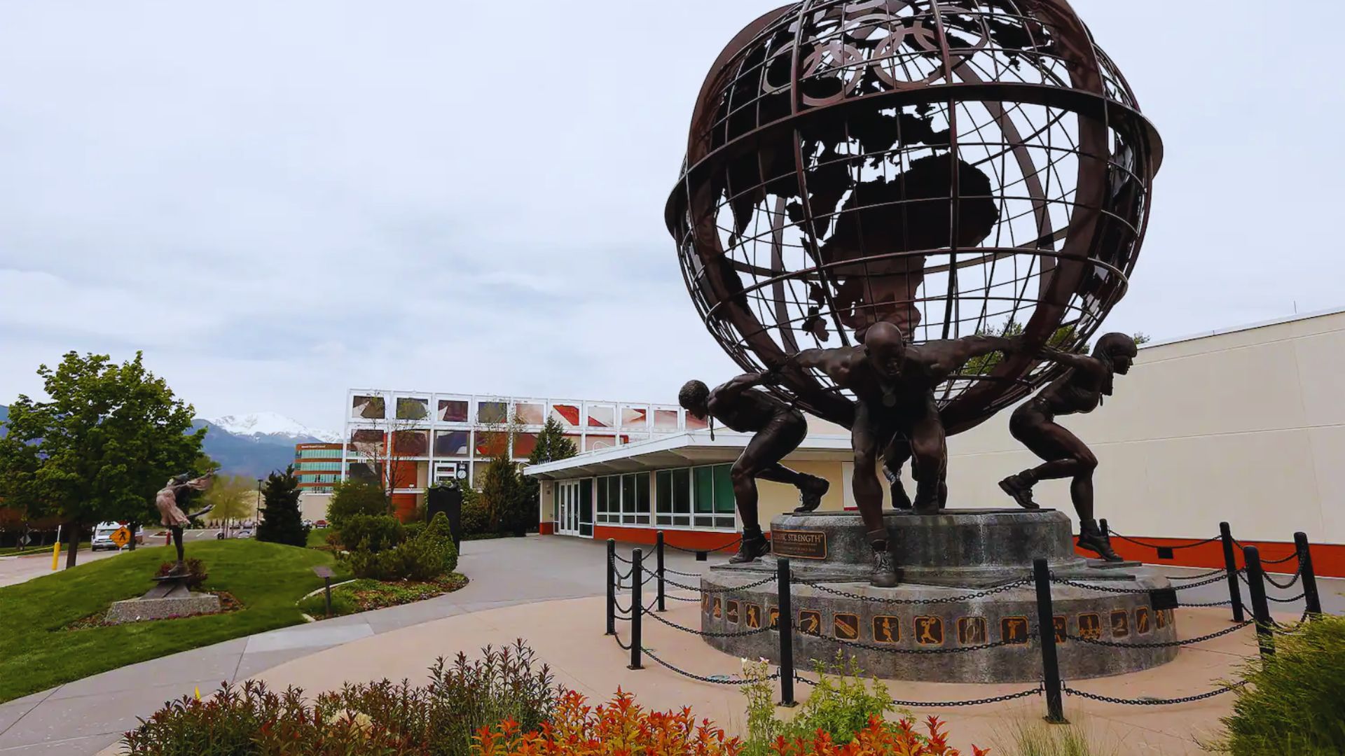A globe statue featuring diverse people standing on its surface, symbolizing unity and global connection.