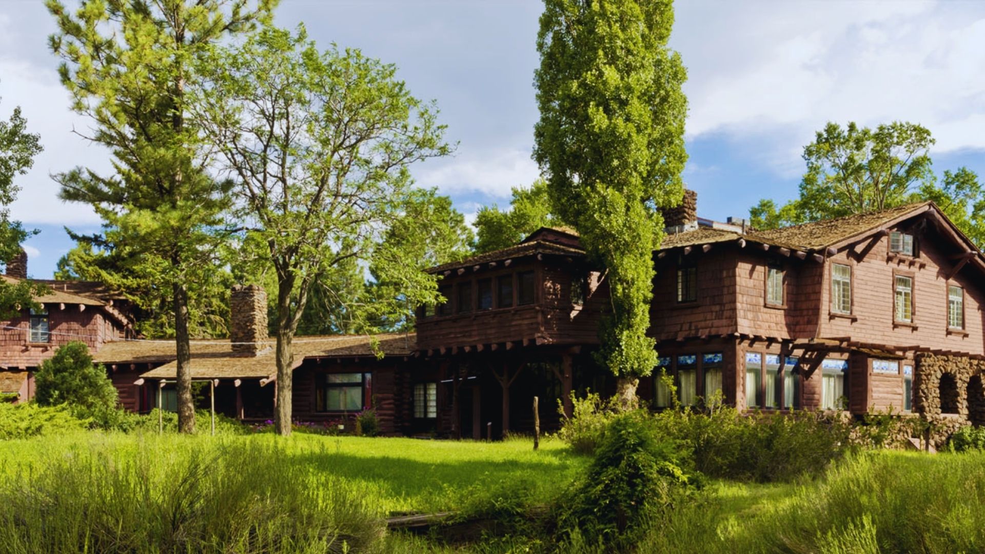 A large wooden house nestled among tall trees, showcasing a serene natural setting.