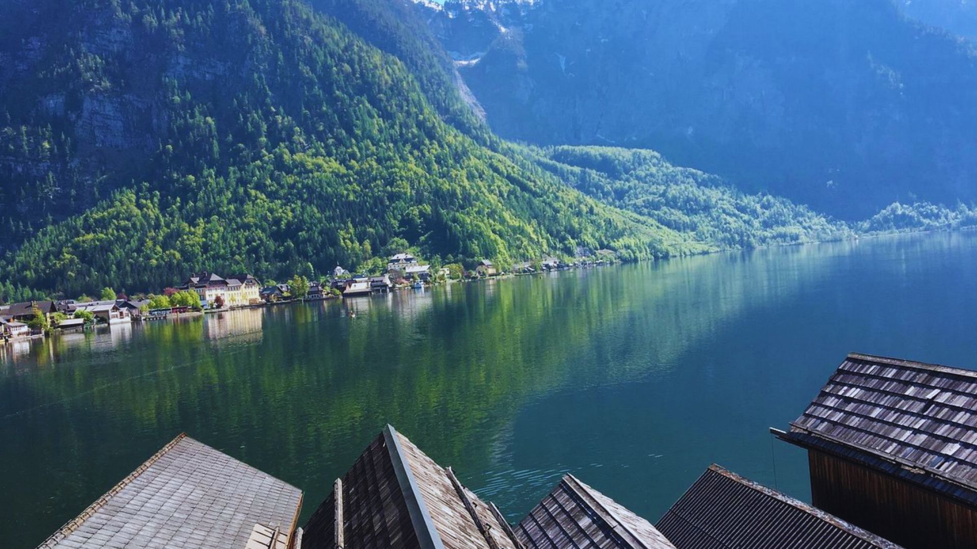 A scenic view of a tranquil lake surrounded by mountains, seen from a balcony.