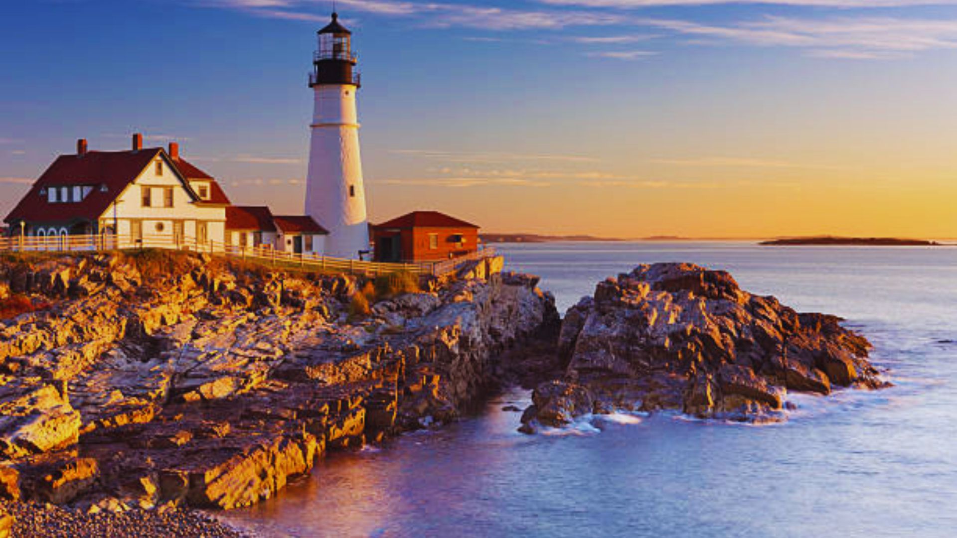 Scenic view of Portland Head Light, a historic lighthouse, surrounded by rocky coastline in Maine, USA.