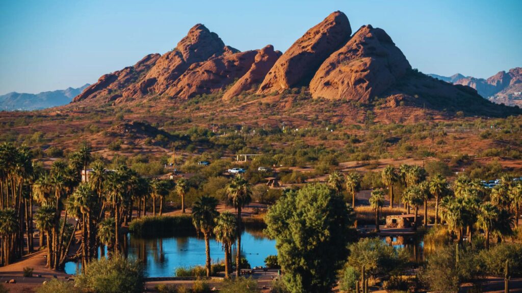 A scenic Arizona desert landscape featuring mountains in the background and palm trees in the foreground.