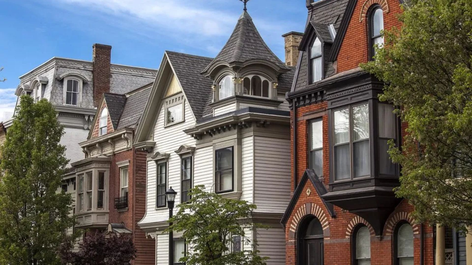 A row of houses featuring red roofs and white trim, showcasing a charming residential neighborhood.