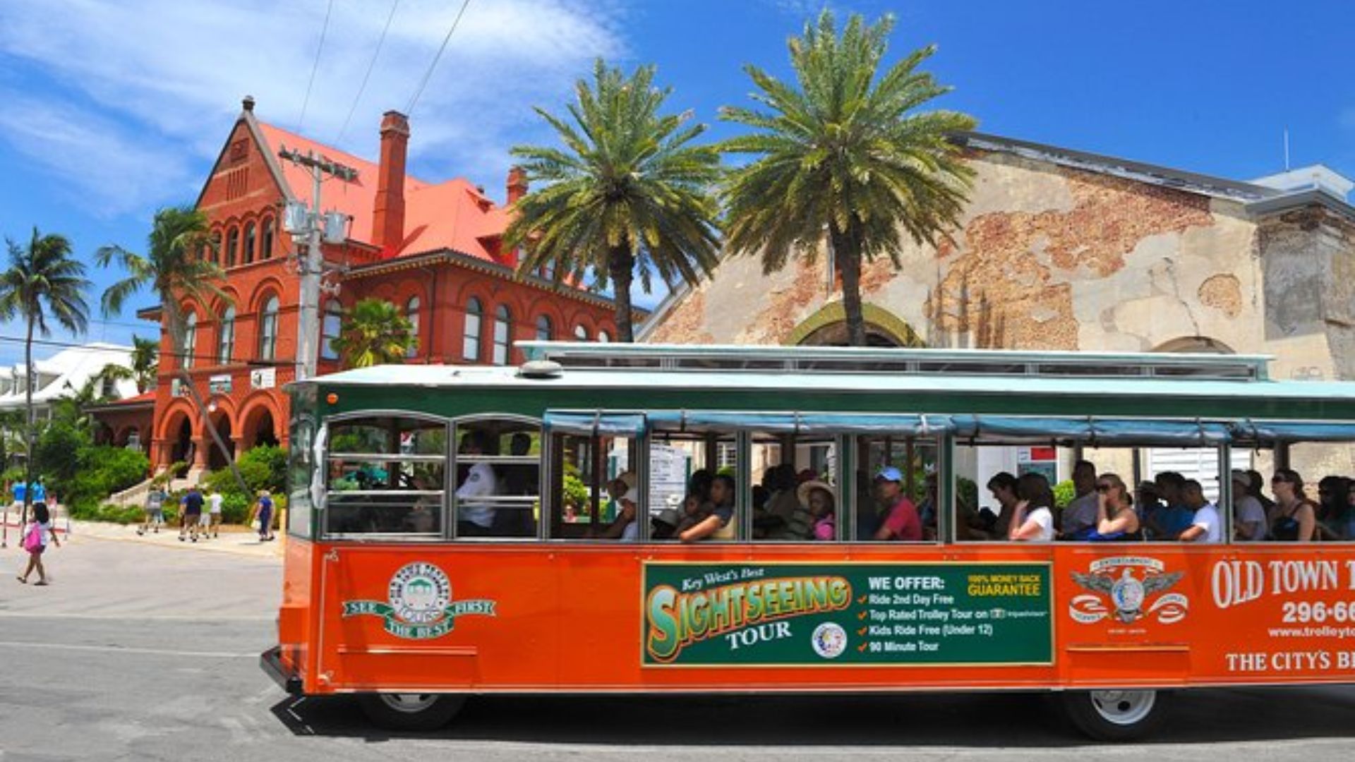 A train filled with passengers traveling along the tracks, showcasing a busy commuting scene.
