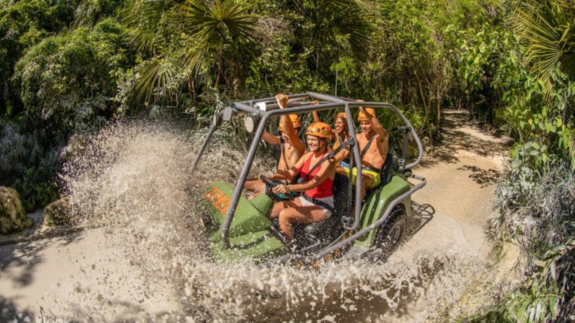 A group of people enjoying a ride on a green vehicle, smiling and engaging with each other.