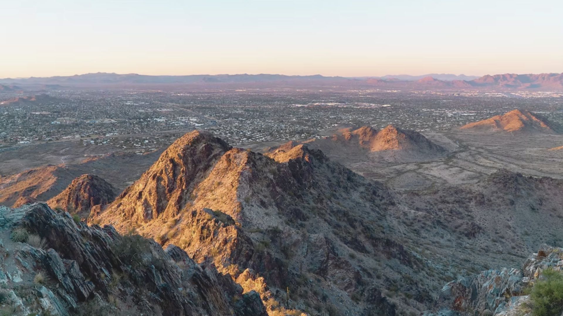 Panoramic view from a mountain peak in Arizona, showcasing vast landscapes and distant horizons under a clear blue sky.