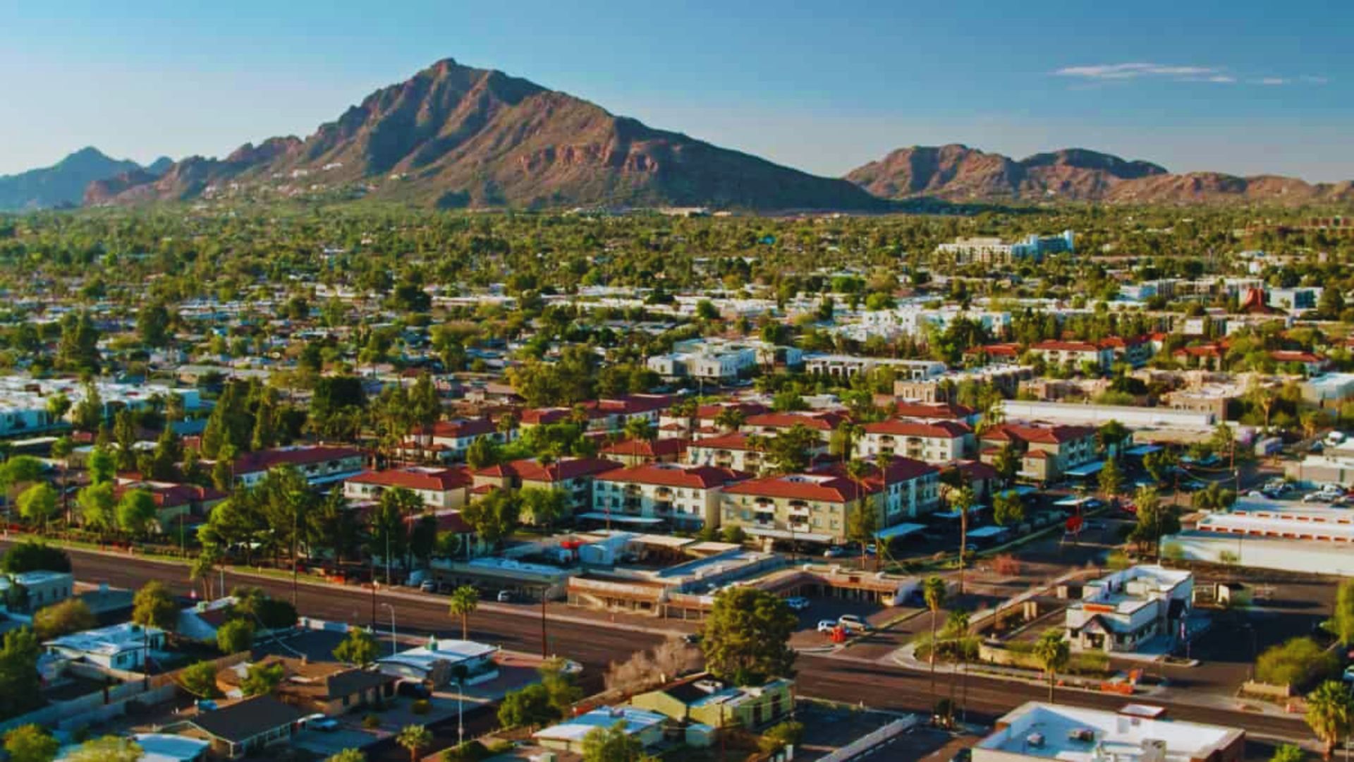 Overhead view of a city in Arizona, showcasing urban structures with mountains rising in the distance.