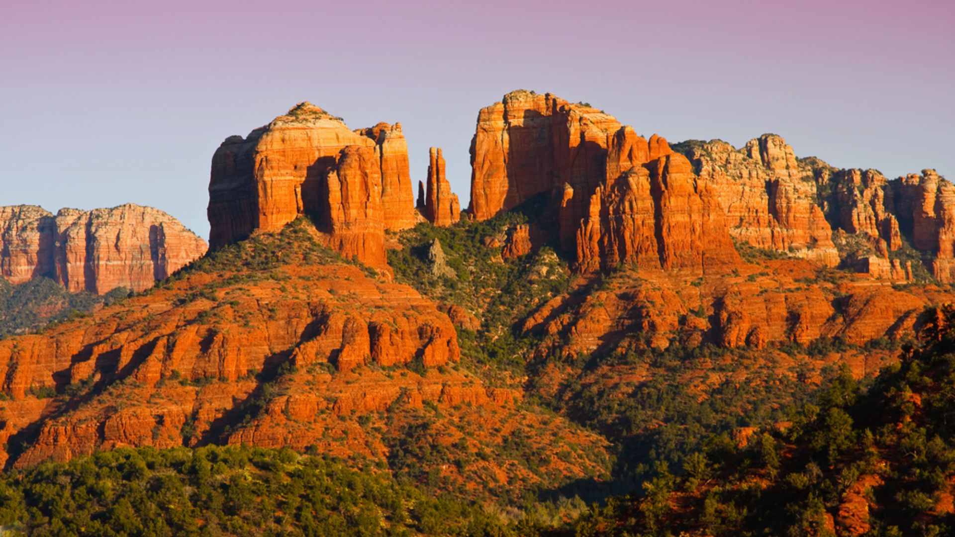 Red rock formations in Sedona, Arizona, showcasing vibrant colors and unique geological shapes against a clear blue sky.