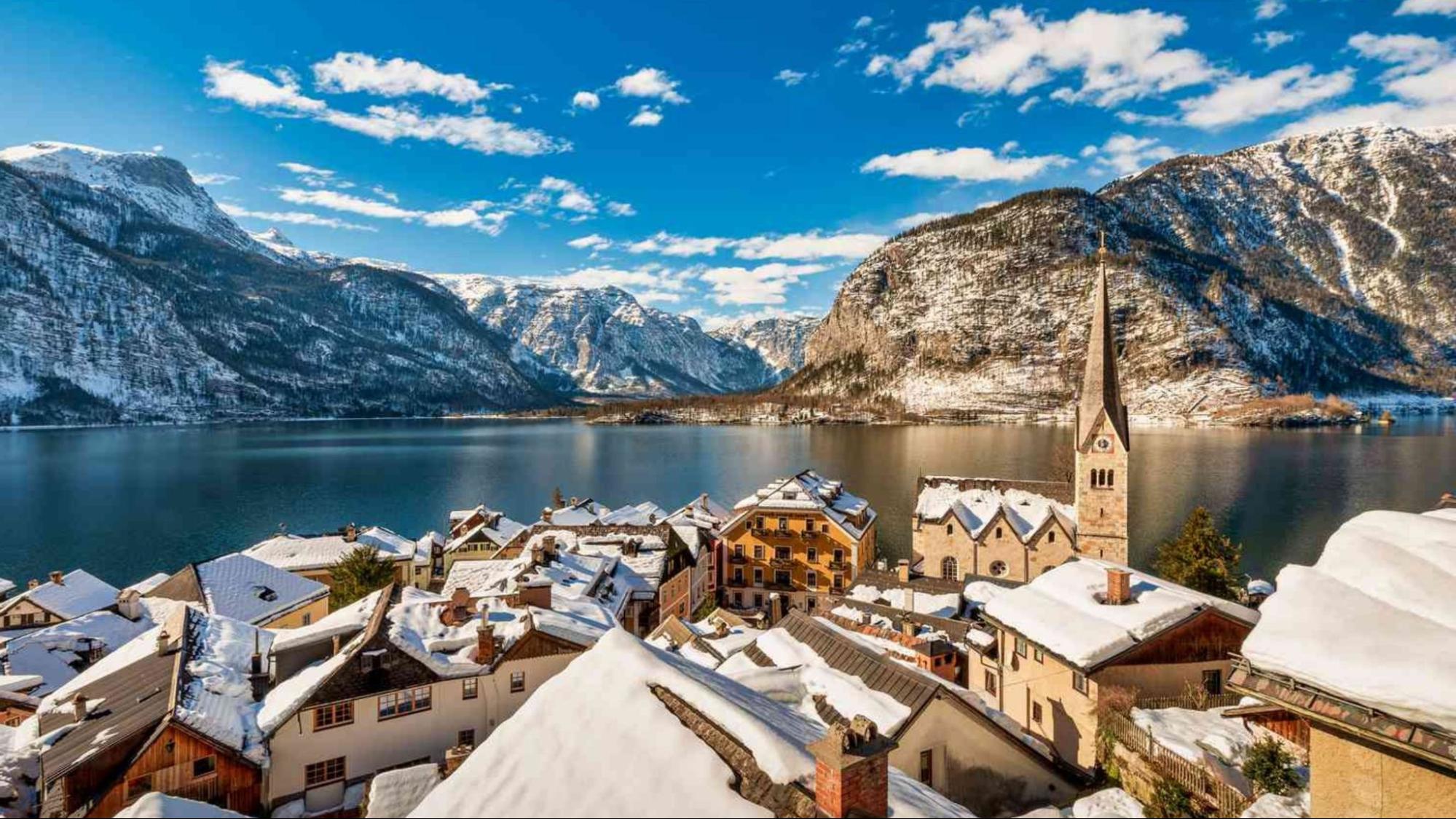 Snow-covered Hallstatt, Austria, showcasing charming alpine architecture and serene winter landscape.