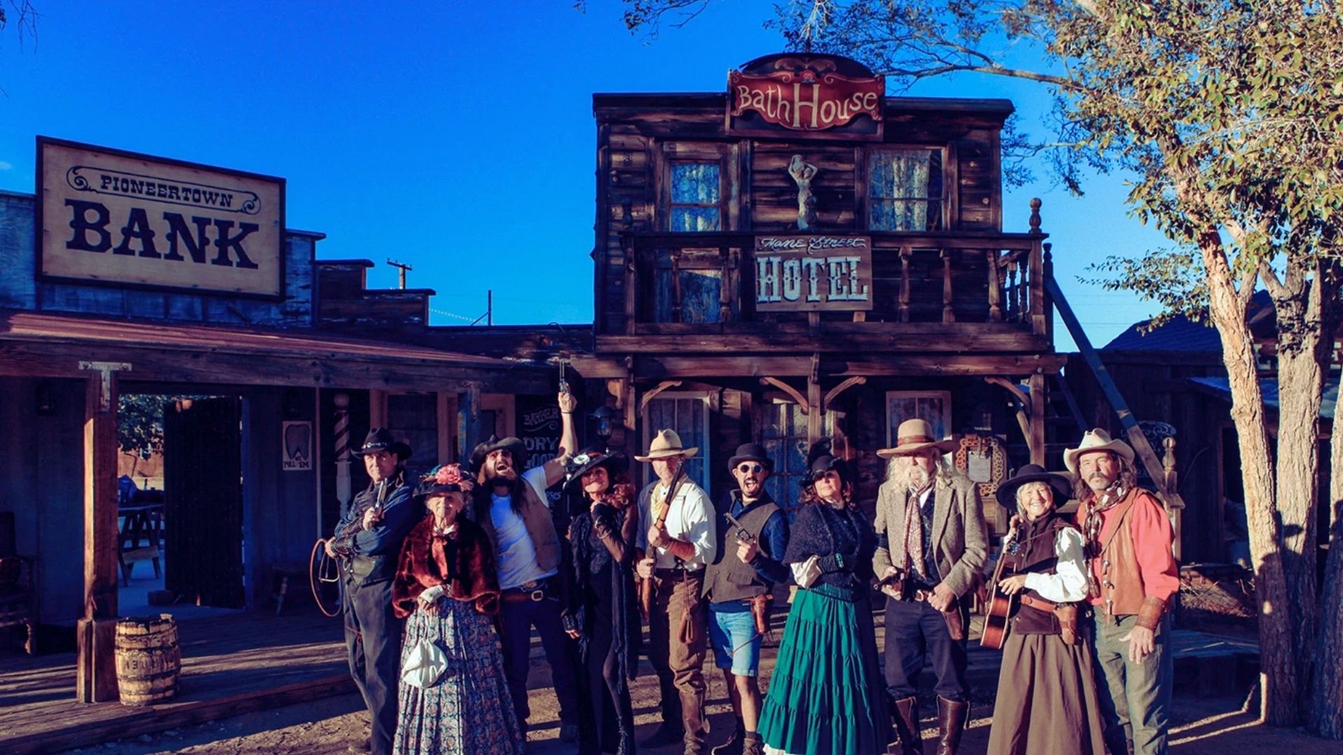A diverse group of people smiling and posing together in front of a modern bank building.