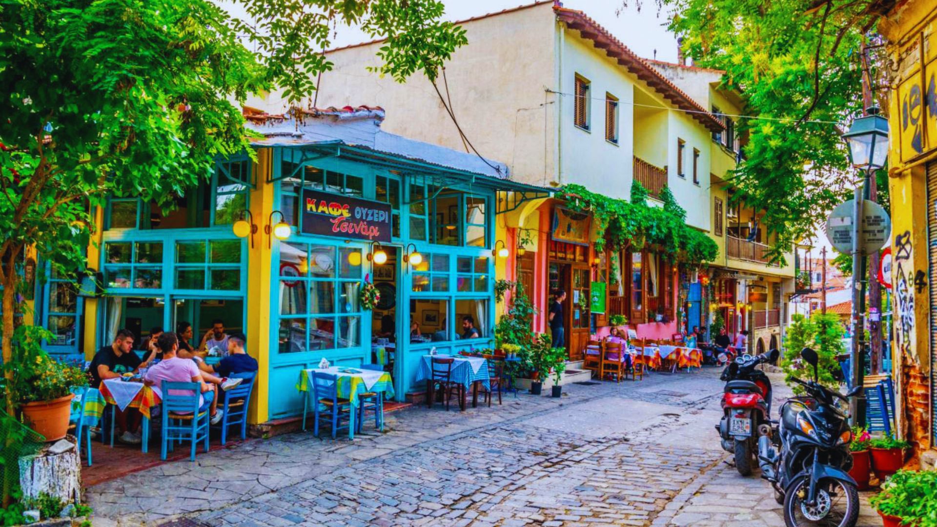 . A vibrant street scene featuring colorful buildings and people enjoying time outdoors at tables.