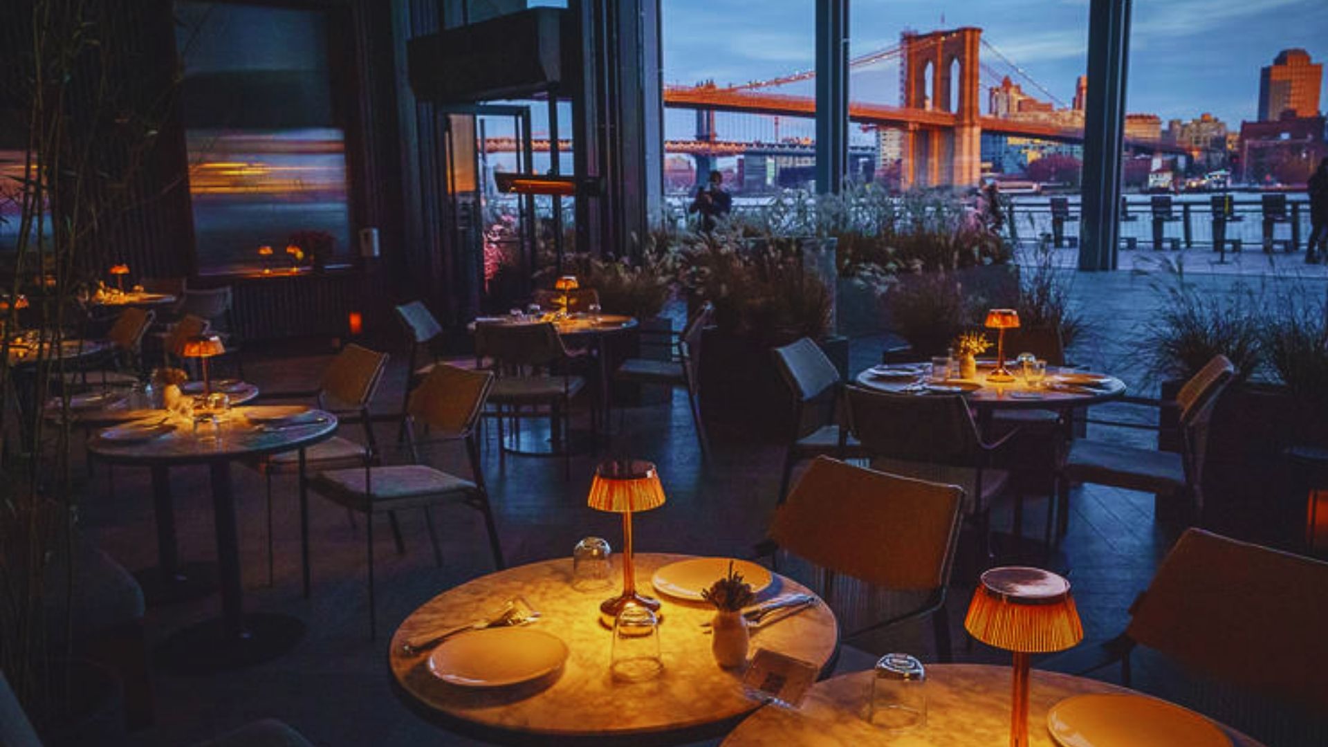 Scenic nighttime view from the restaurant showcasing the Brooklyn Bridge lit up against the night skyline.
