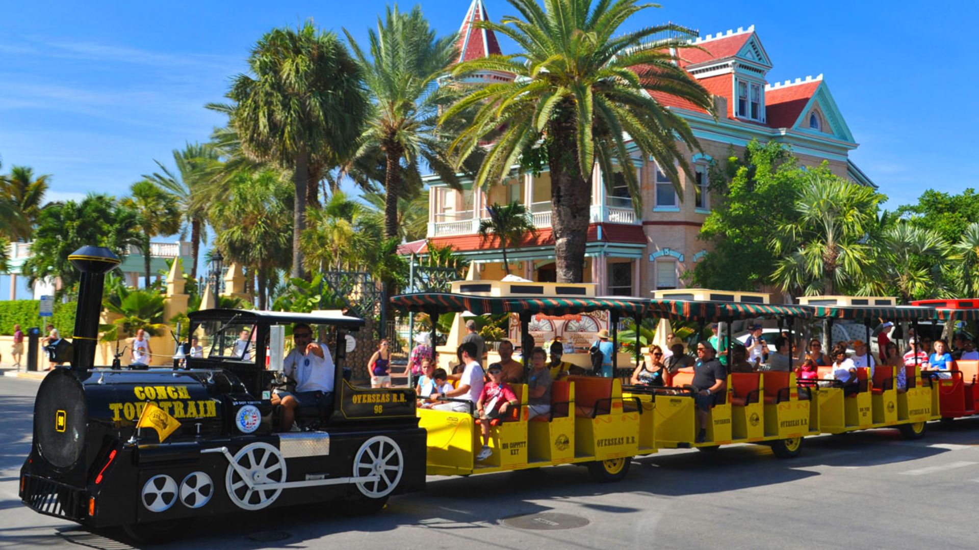 A train filled with passengers traveling along the tracks, showcasing a busy commuting scene.