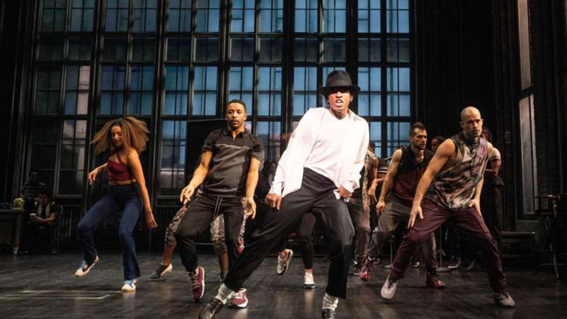The cast of Michael Jackson's "This Is It" poses together, showcasing their vibrant costumes and energetic expressions.