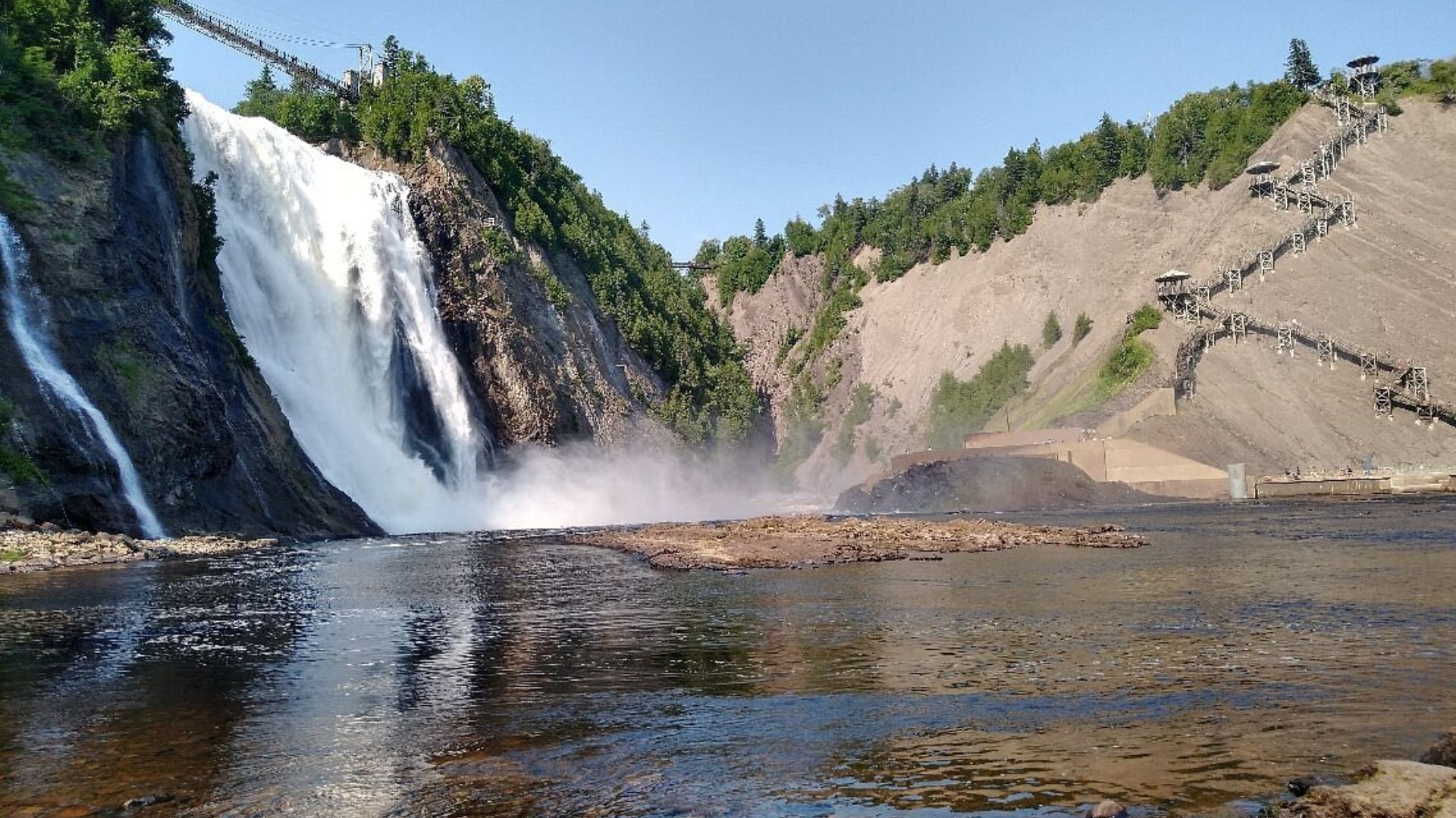 A majestic waterfall flows powerfully into a tranquil lake.