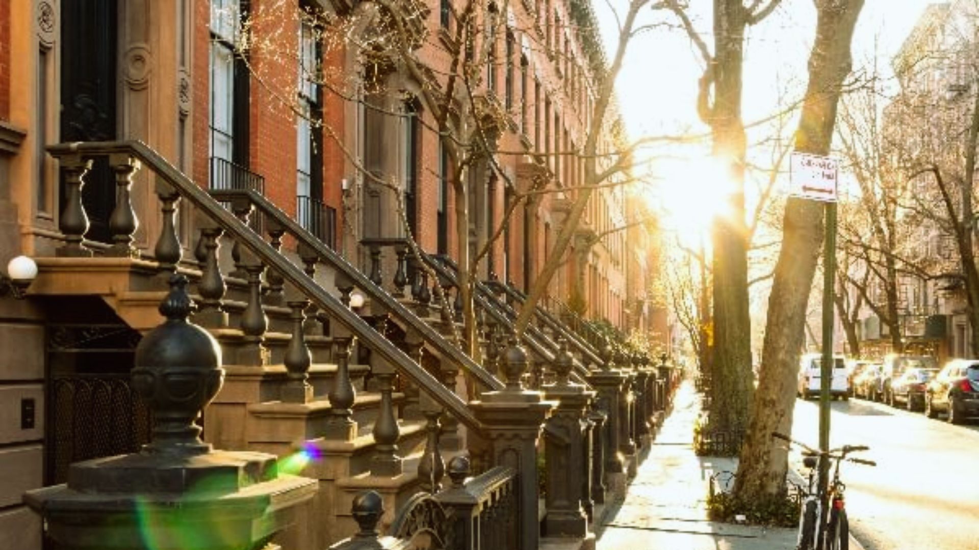 A street scene featuring a parked bike alongside the curb.