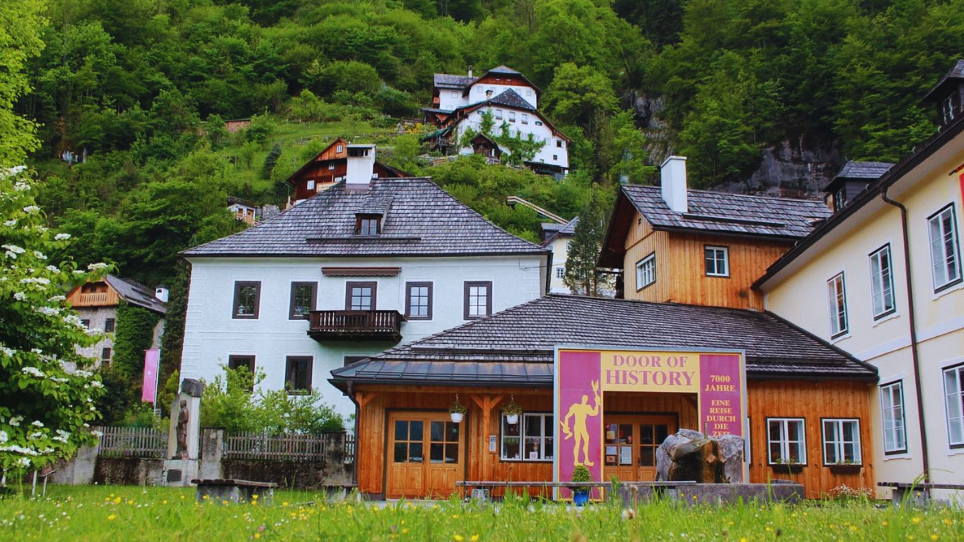 A building featuring a sign that reads "the museum of the history of the village" prominently displayed at the entrance.