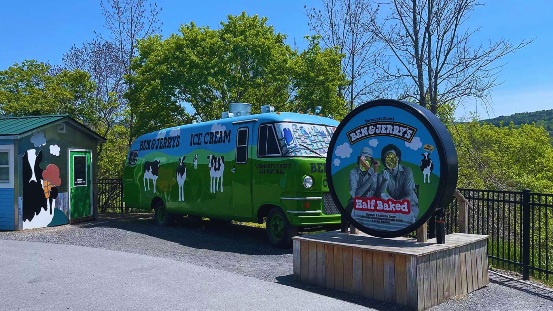 A green and blue bus parked in front of a building, showcasing its vibrant colors against the urban backdrop.