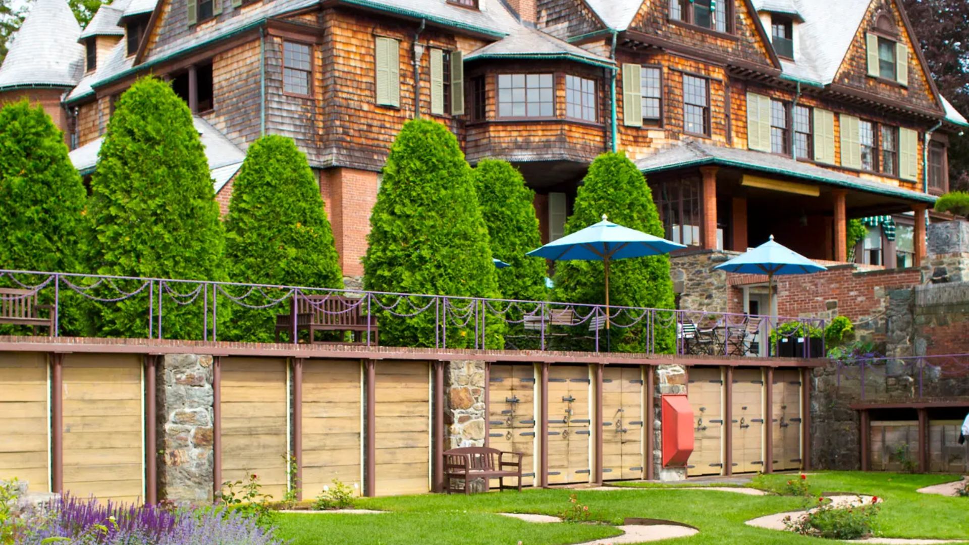 A large house surrounded by a spacious lawn and enclosed by a wooden fence.