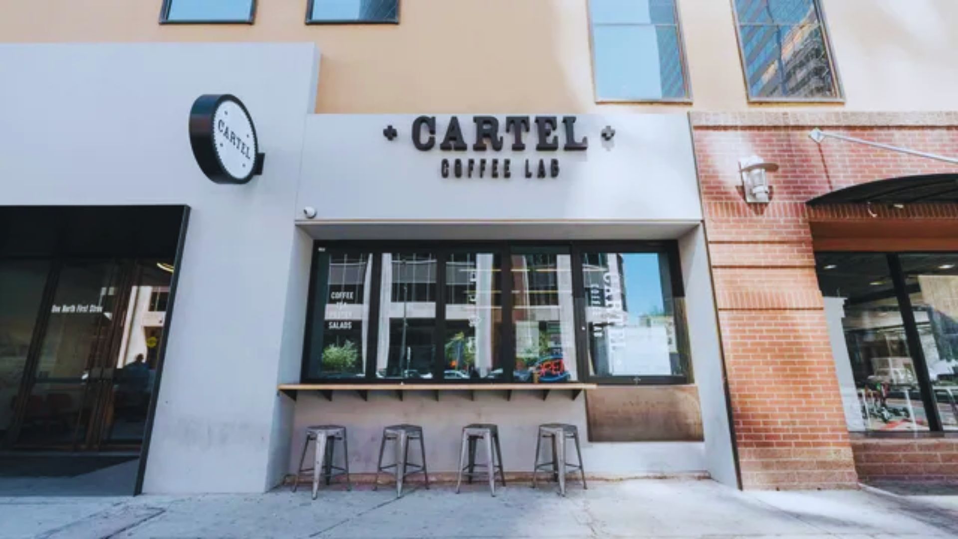 Carlsberg coffee shop exterior in downtown San Diego, featuring outdoor seating and a bustling urban atmosphere.