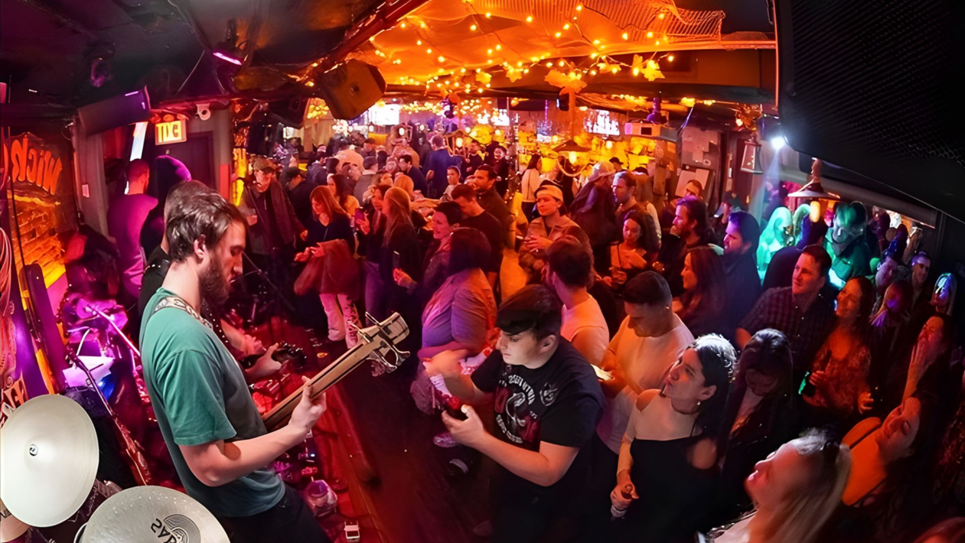A lively bar scene filled with people playing various musical instruments and enjoying the vibrant atmosphere.