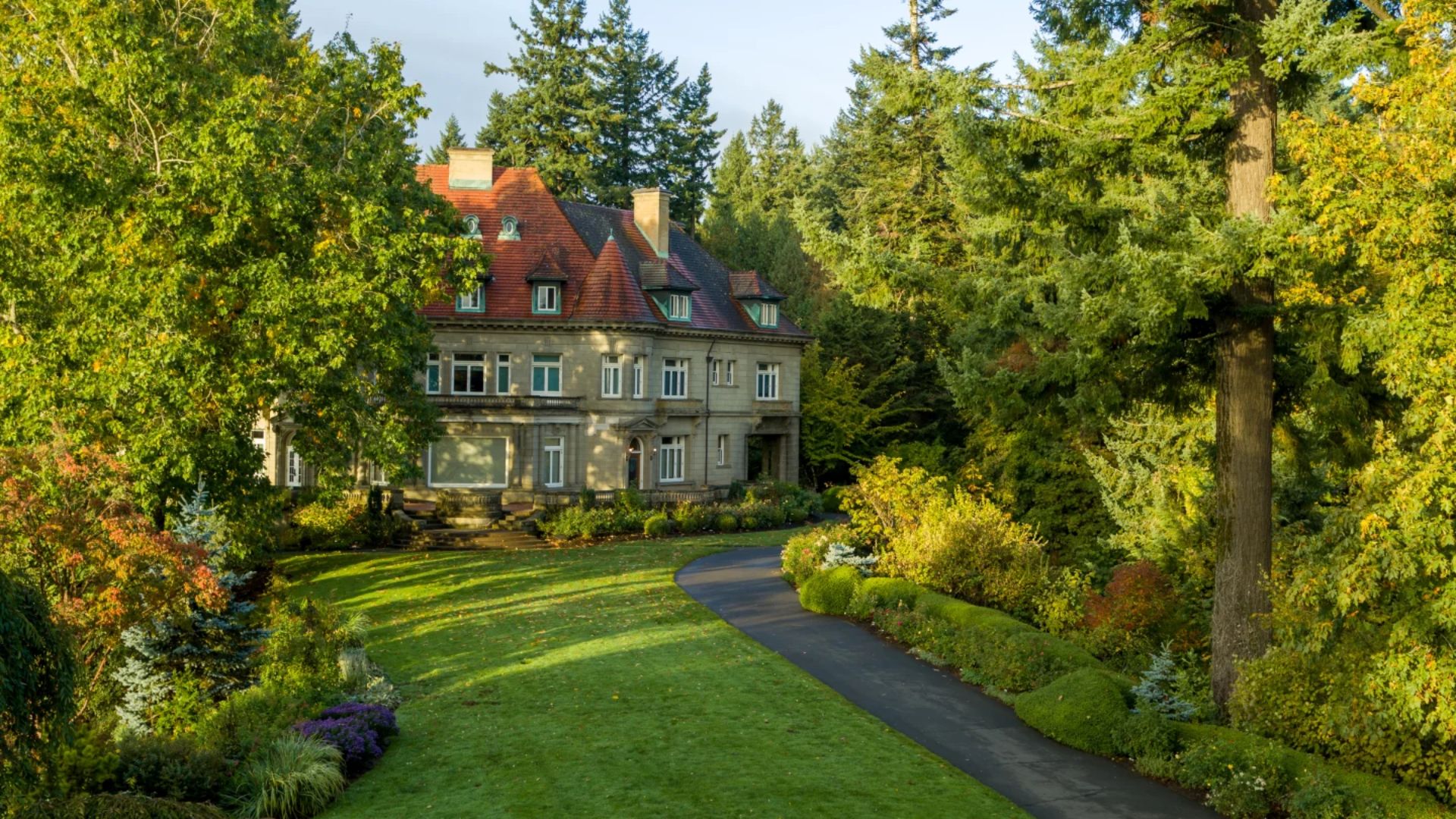 A large house nestled among lush trees and vibrant bushes, creating a serene and natural environment.