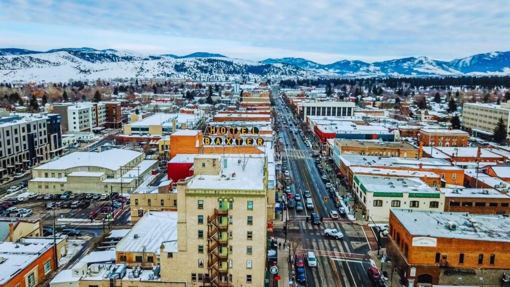 Aerial view of a snow-covered city, showcasing rooftops and streets blanketed in white.