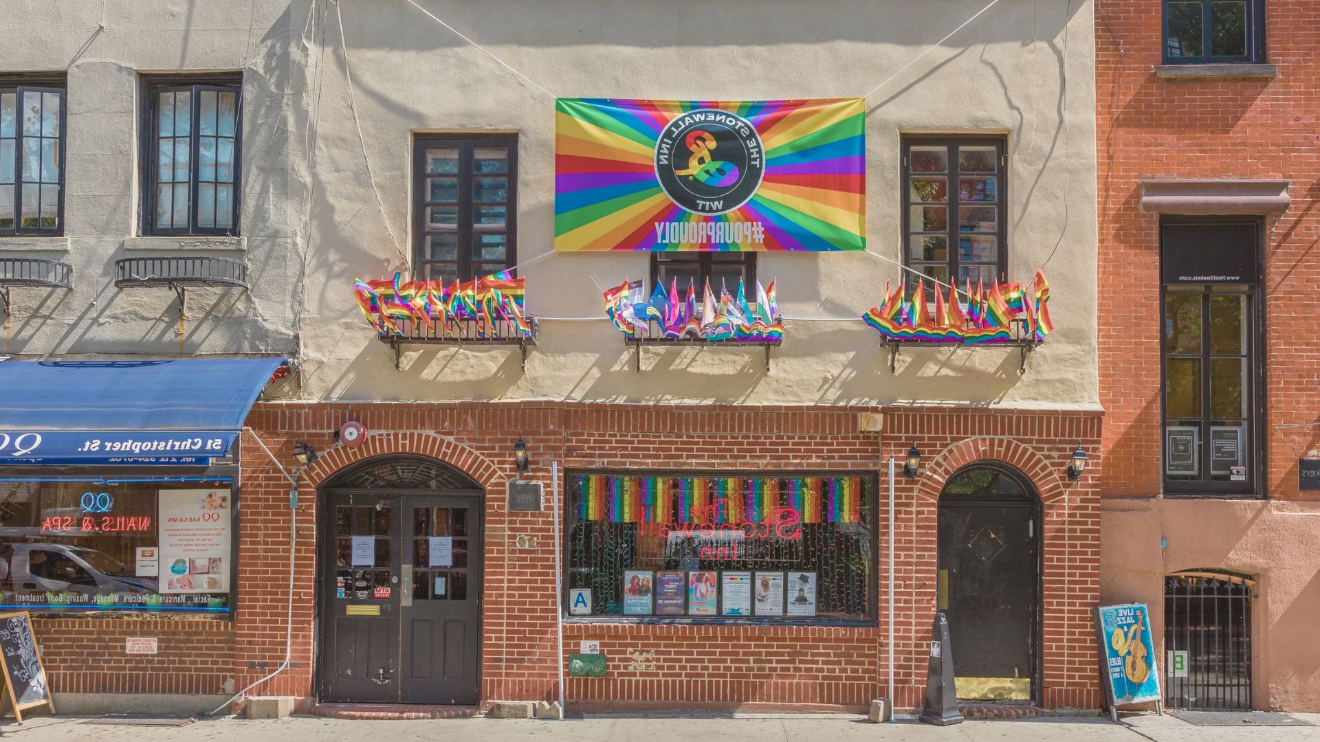 A rainbow flag is displayed prominently on the front of a building, symbolizing LGBTQ+ pride and inclusivity.