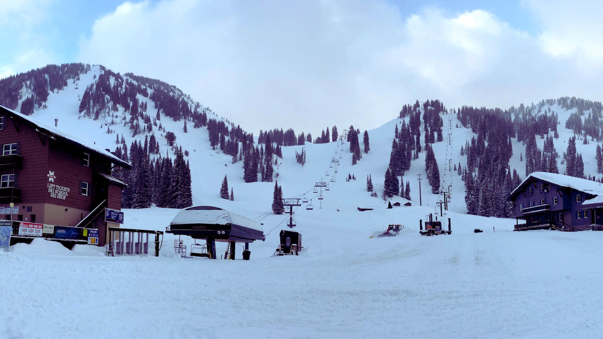 A scenic ski resort featuring a ski lift and a cozy lodge surrounded by snow-covered mountains.