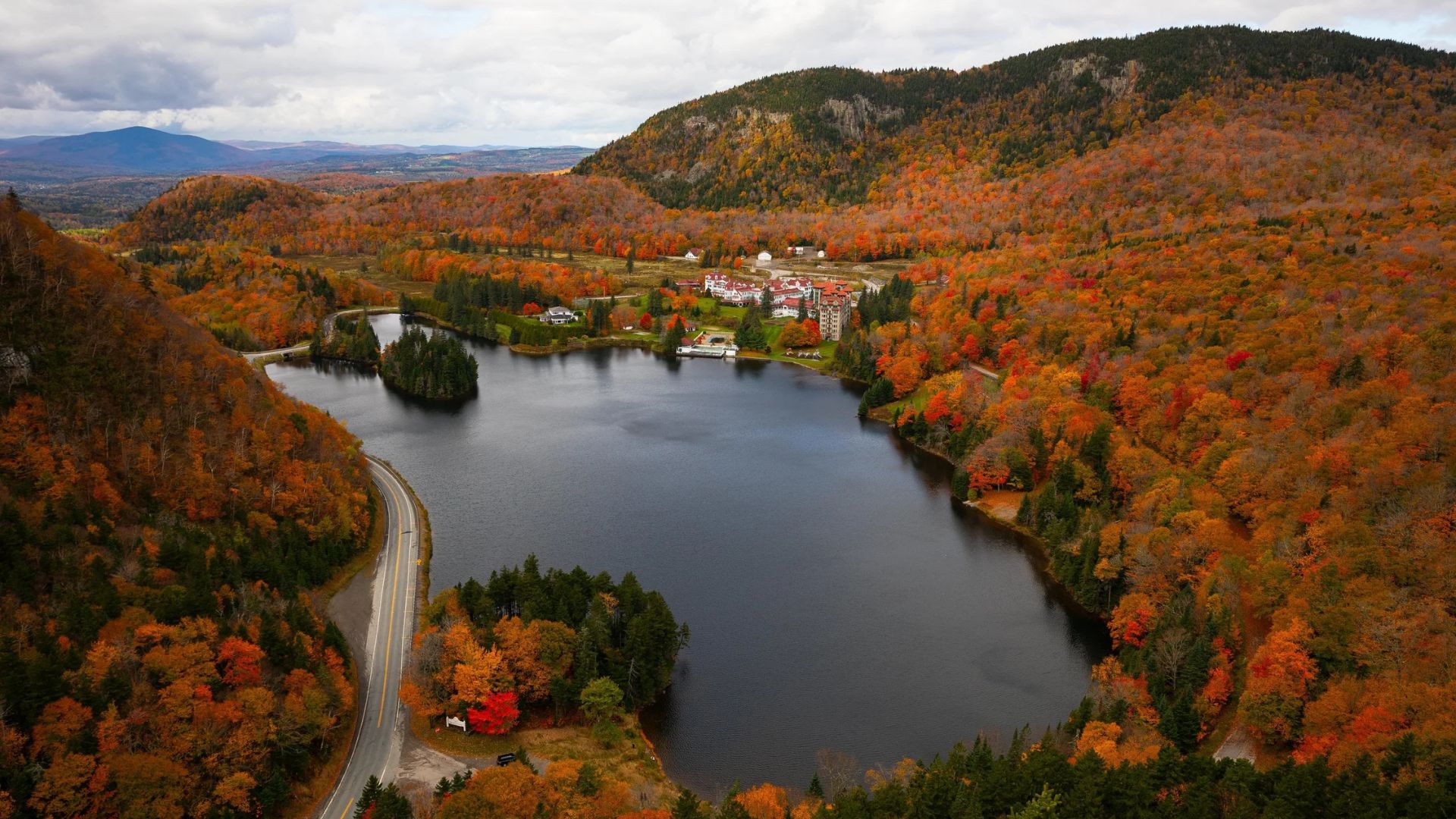 Aerial view of a serene lake encircled by lush green trees, showcasing the natural beauty of the landscape.